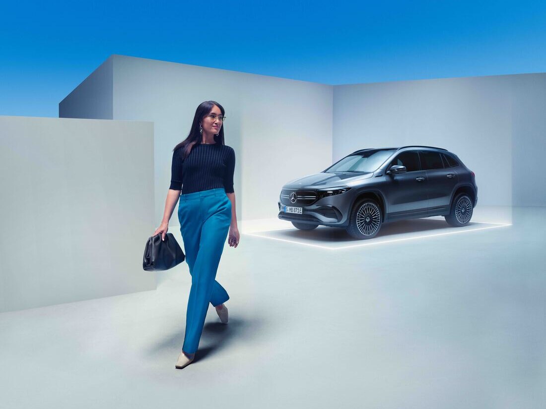 Uma mulher afasta-se do seu Mercedes-Benz estacionado.