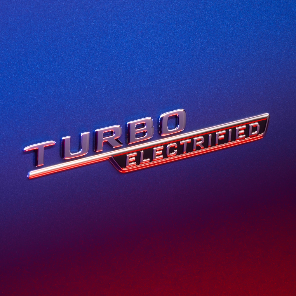Símbolo TURBO E PERFORMANCE no guarda-lamas dianteiro, iluminado por uma luz vermelha. 