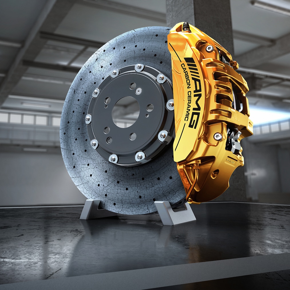 Vista detalhada de um disco de travão de material compósito de cerâmica de alta performance AMG com uma pinça do travão em amarelo.