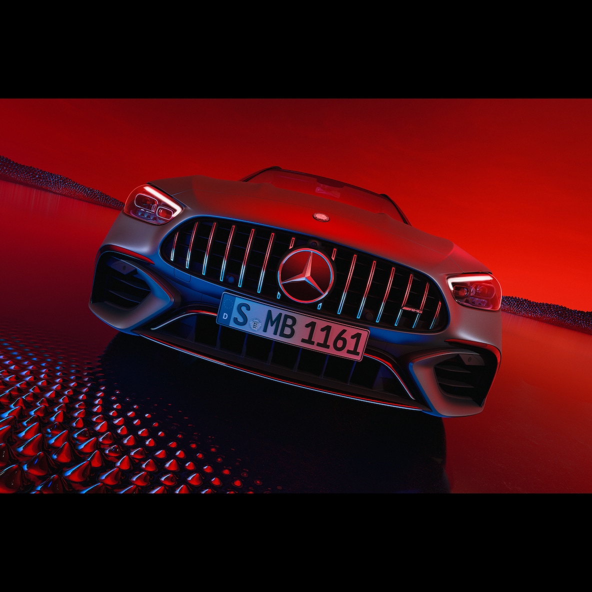 Vista frontal do Mercedes-AMG C 63 S E PERFORMANCE, sobre um fundo vermelho.