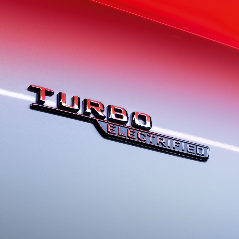 Grande plano do emblema TURBO ELECTRIFIED nos guarda-lamas dianteiros.