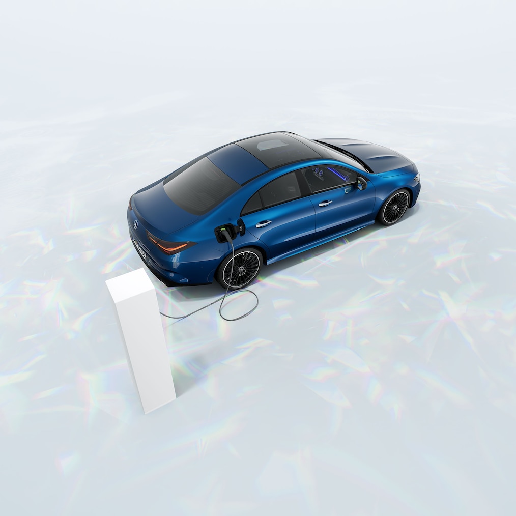 Vista de um Mercedes-Benz CLA 250 e Coupé com tecnologia híbrida EQ parado numa estação de carregamento.