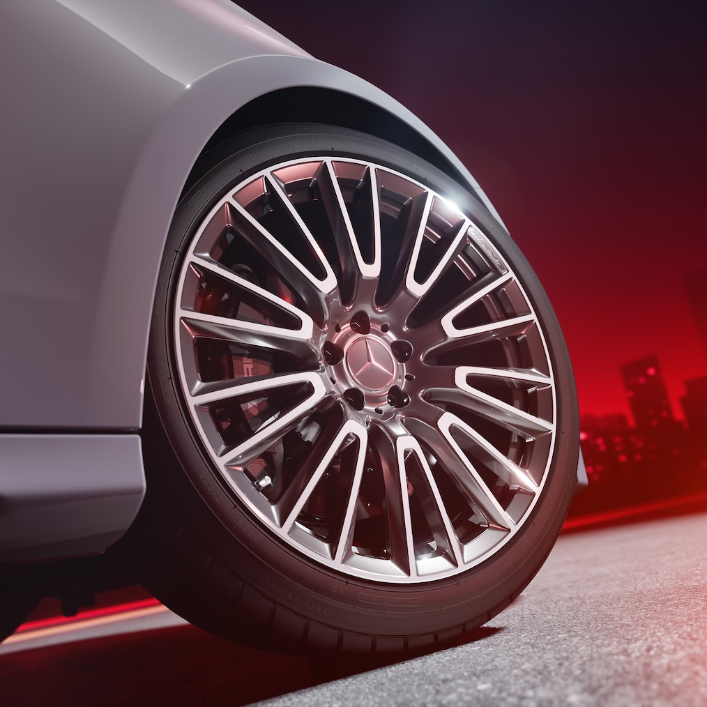 Vista detalhada de uma jante forjada AMG com sistema de travagem de alto desempenho AMG com pinças dos travões em vermelho.