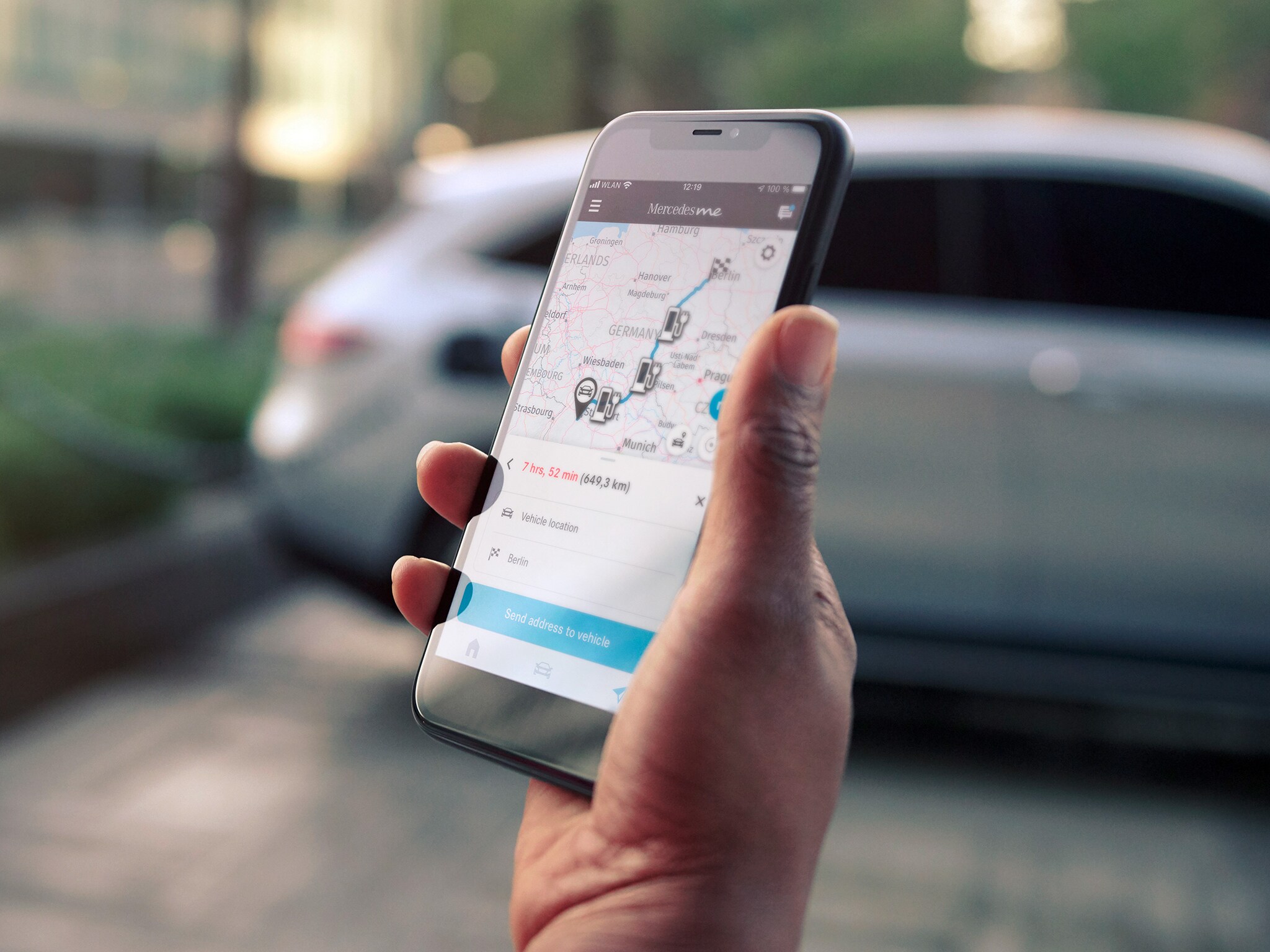 Uma mão segura um smartphone para planear uma rota