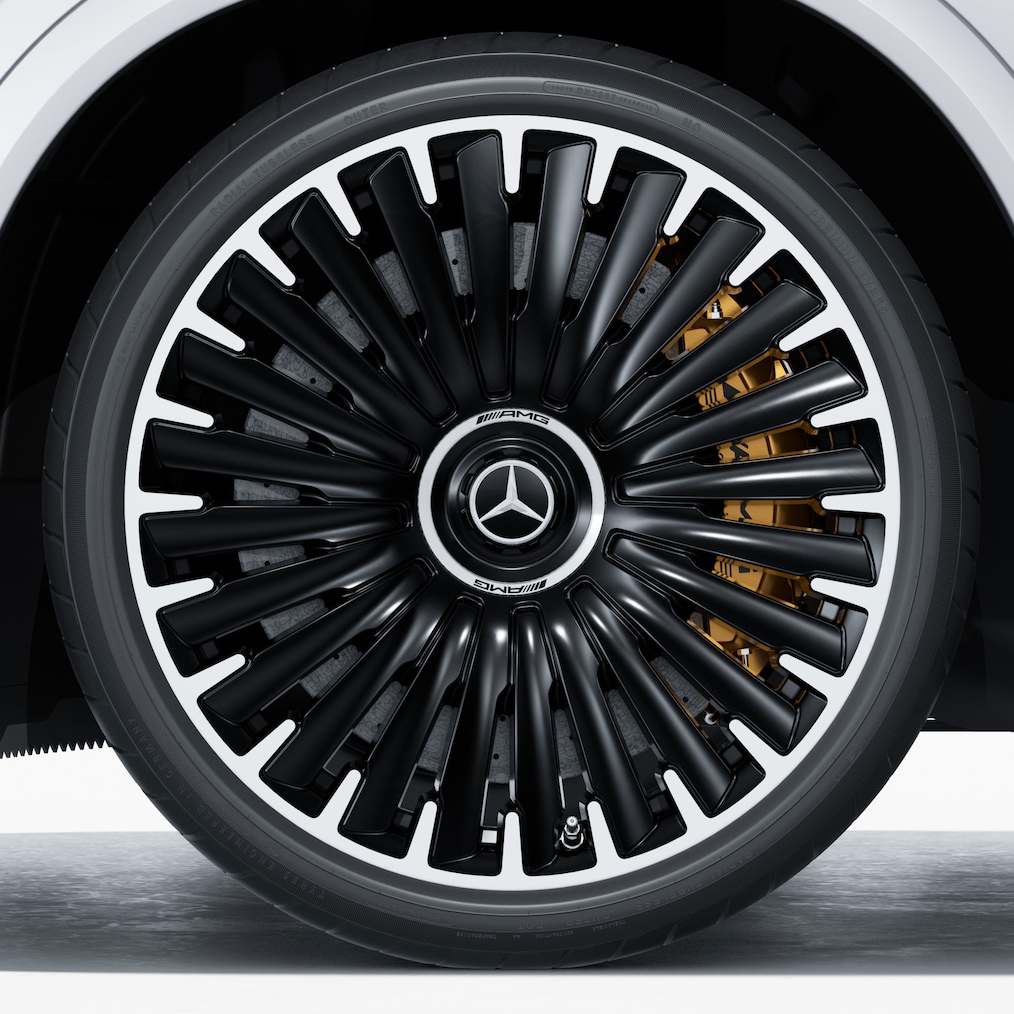 Vista detalhada de uma jante de liga leve AMG com o sistema de travagem de material compósito de cerâmica de alto desempenho AMG a brilhar.