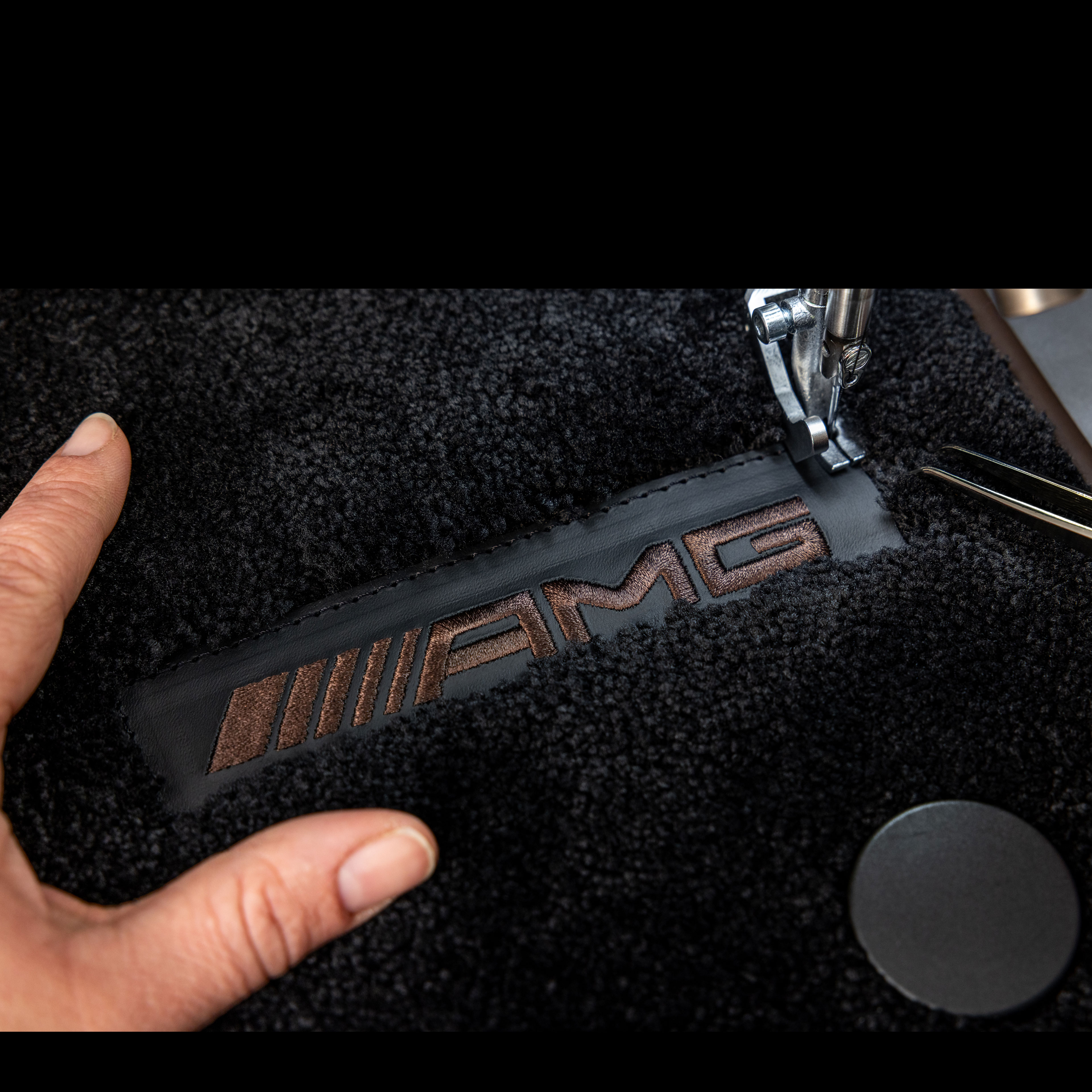 MANUFAKTUR | Mercedes-AMG Inscrição MANUFAKTUR sobre uma superfície escura num Mercedes-AMG.