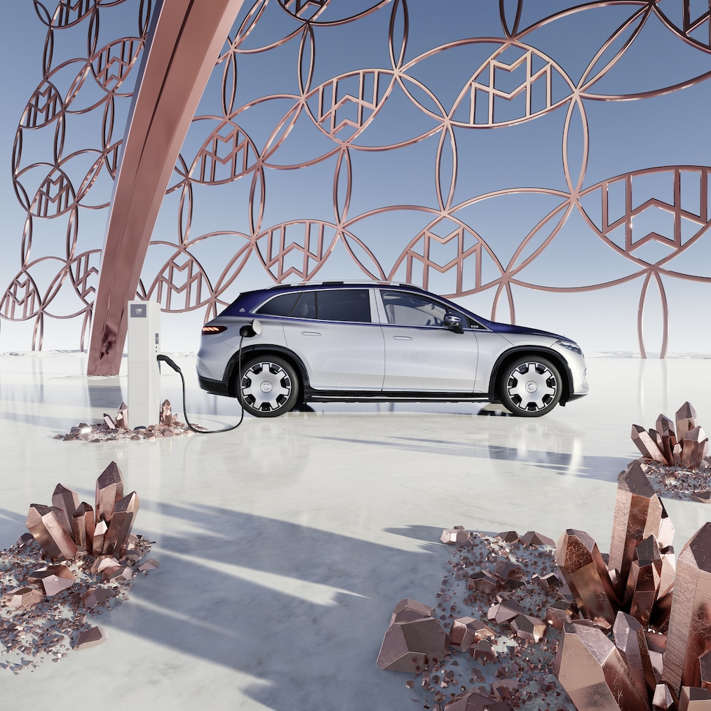 Vista lateral do SUV Mercedes-Maybach EQS na estação de carregamento, com o logótipo da marca Maybach ao fundo.