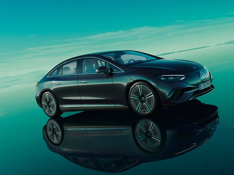 O EQE totalmente elétrico da Mercedes-EQ no seu mundo EQ verde com uma superfície de piso refletora.