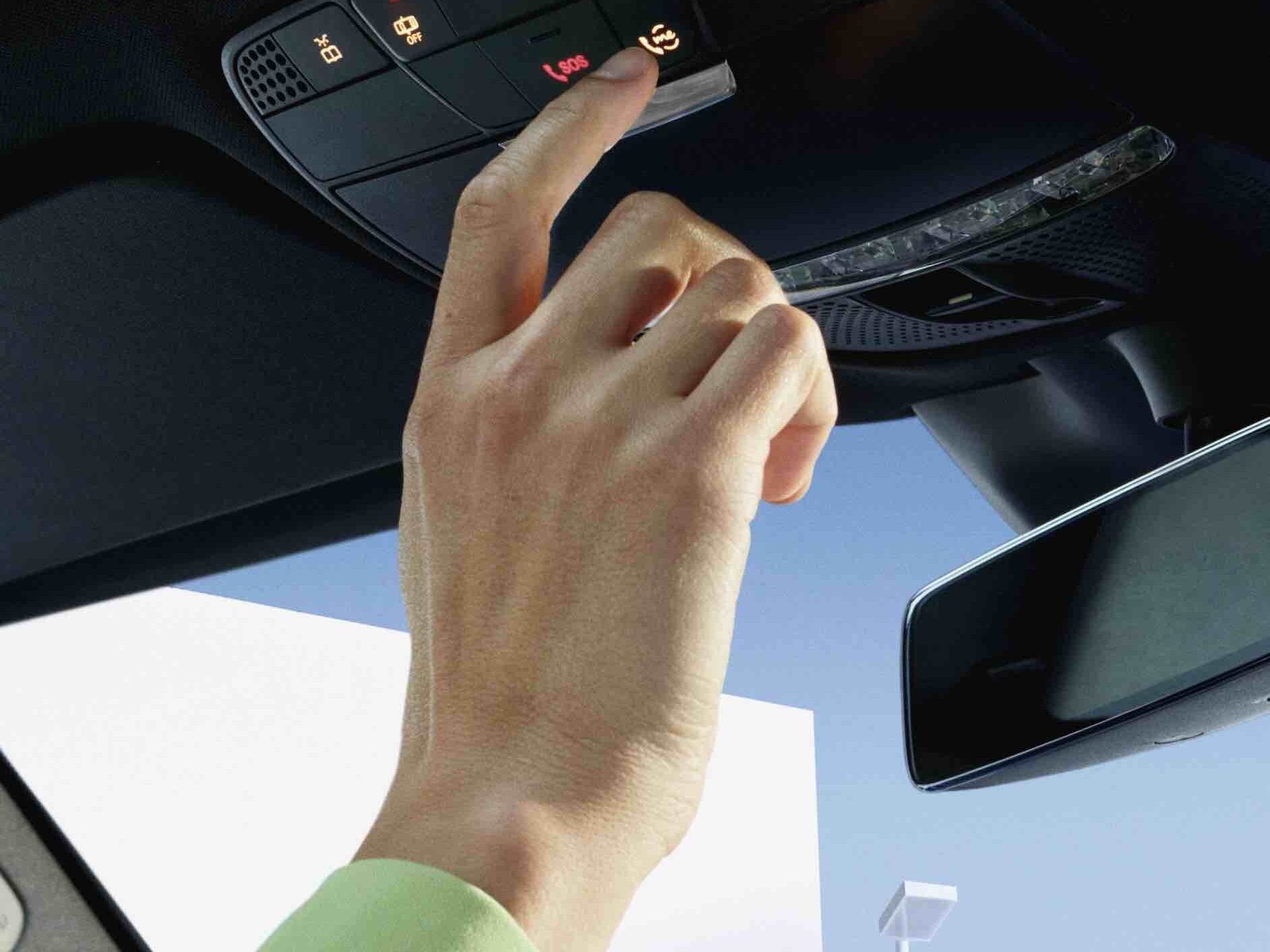 A tecla Mercedes me na unidade de comando do teto de um Mercedes-Benz é pressionada.
