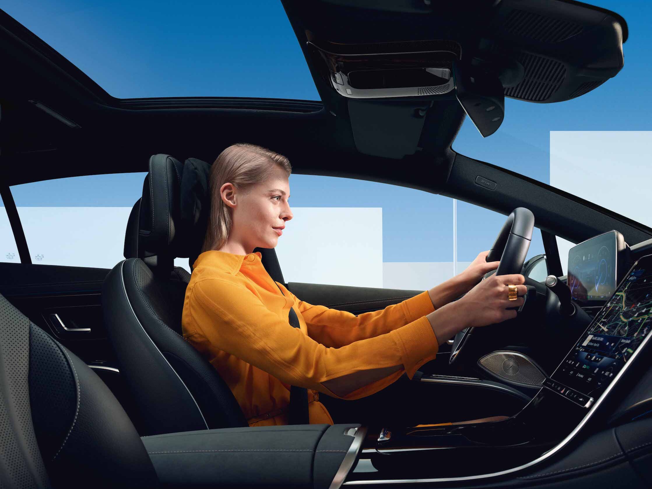 Uma mulher encontra-se ao volante no seu Mercedes-Benz.