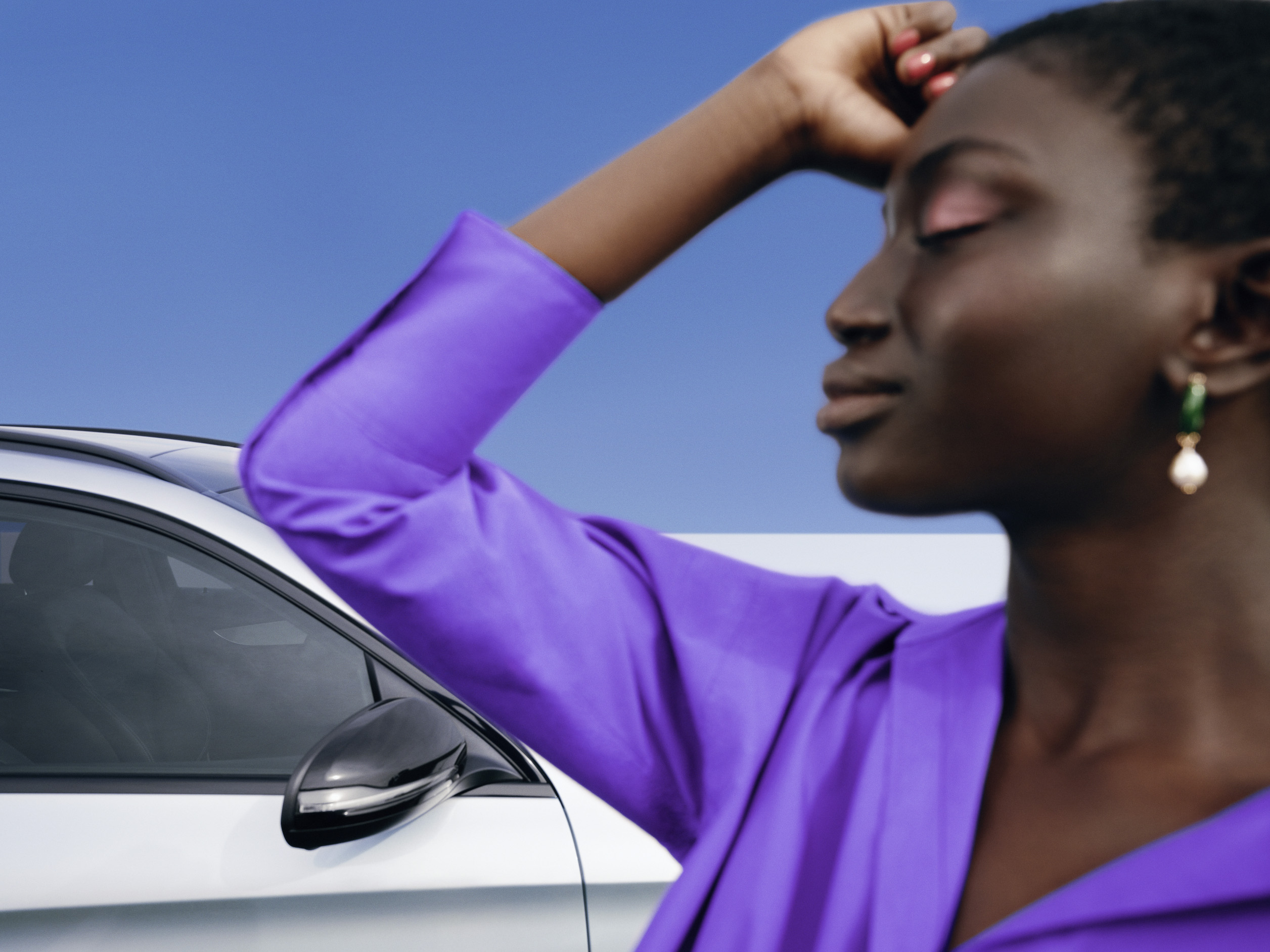 Mercedes-Benz | Produtos de conservação originais Uma mulher está de pé, descontraída, com uma expressão fechada, diante do seu Mercedes.