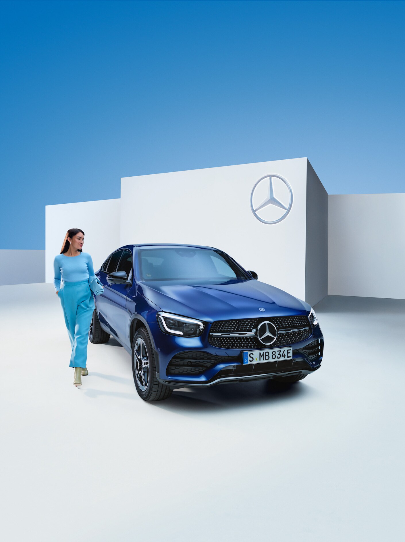 Uma mulher está ao lado do seu Mercedes-Benz.
