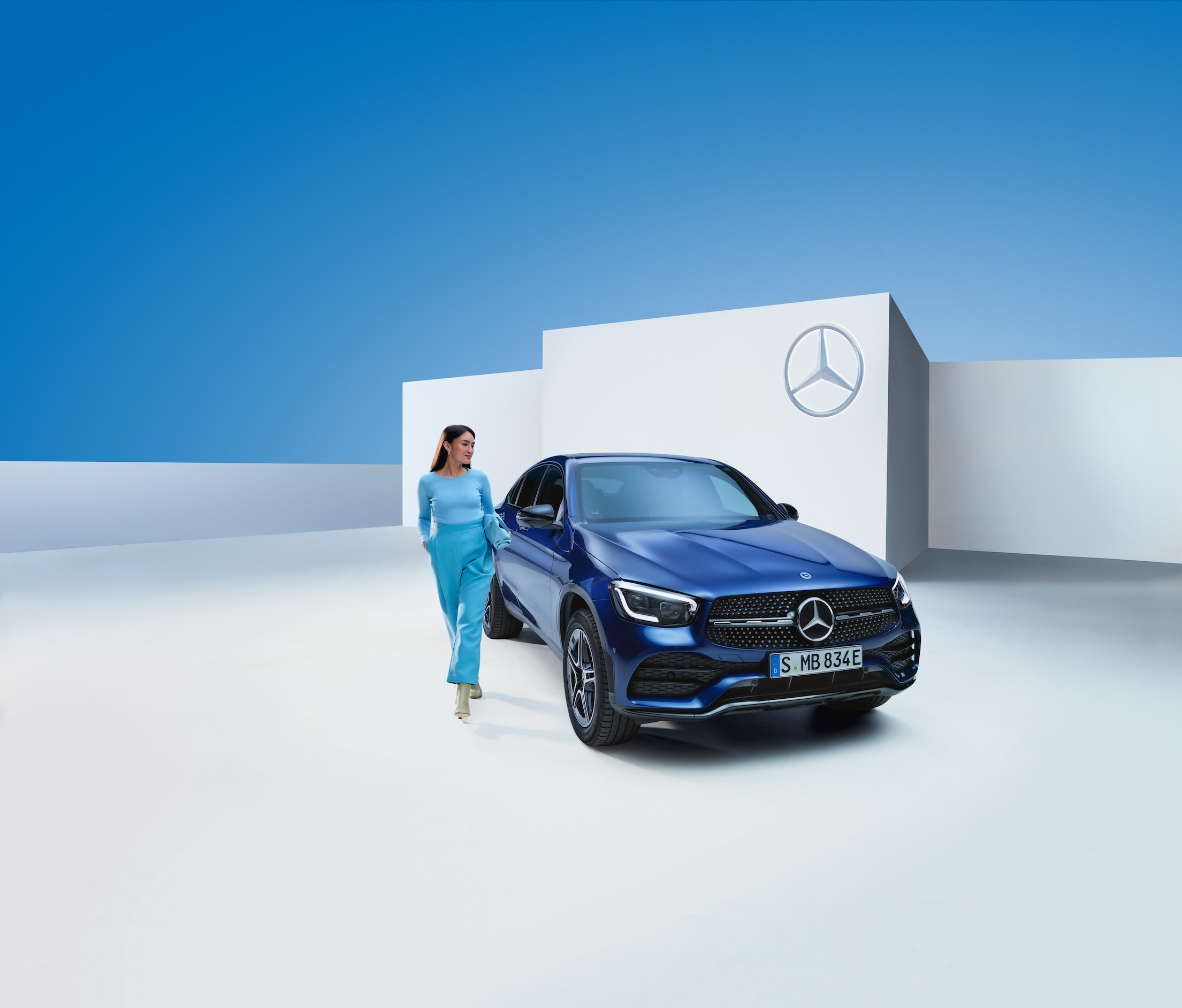 Mercedes-Benz | Produtos de conservação originais Uma mulher está ao lado do seu Mercedes-Benz.