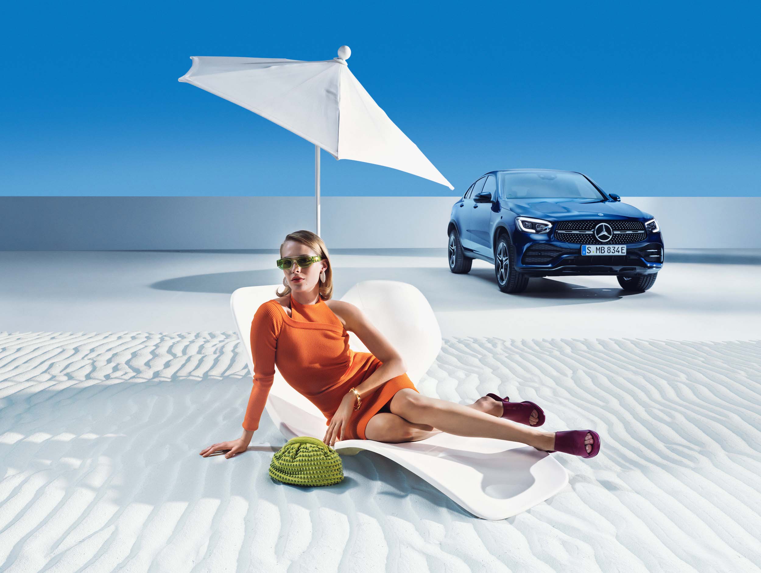 Mercedes-Benz | Produtos de conservação originais Uma mulher relaxa na praia diante do seu Mercedes-Benz.