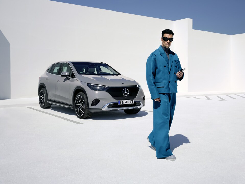 Um homem parado em frente ao seu Mercedes-Benz.