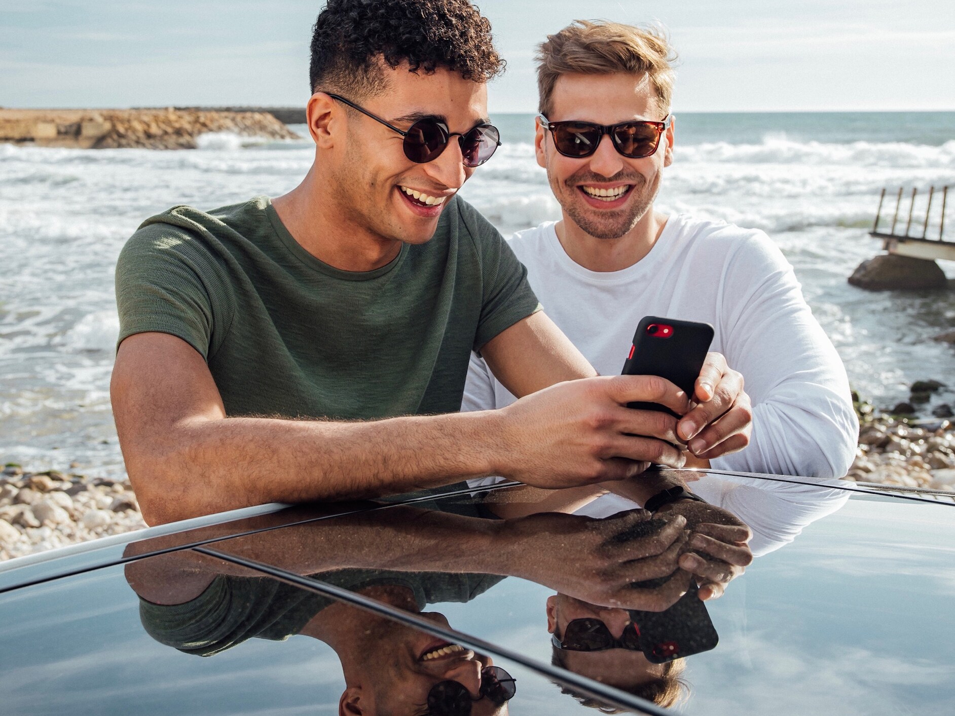 Dois homens vêm a sua Driver Score no smartphone.