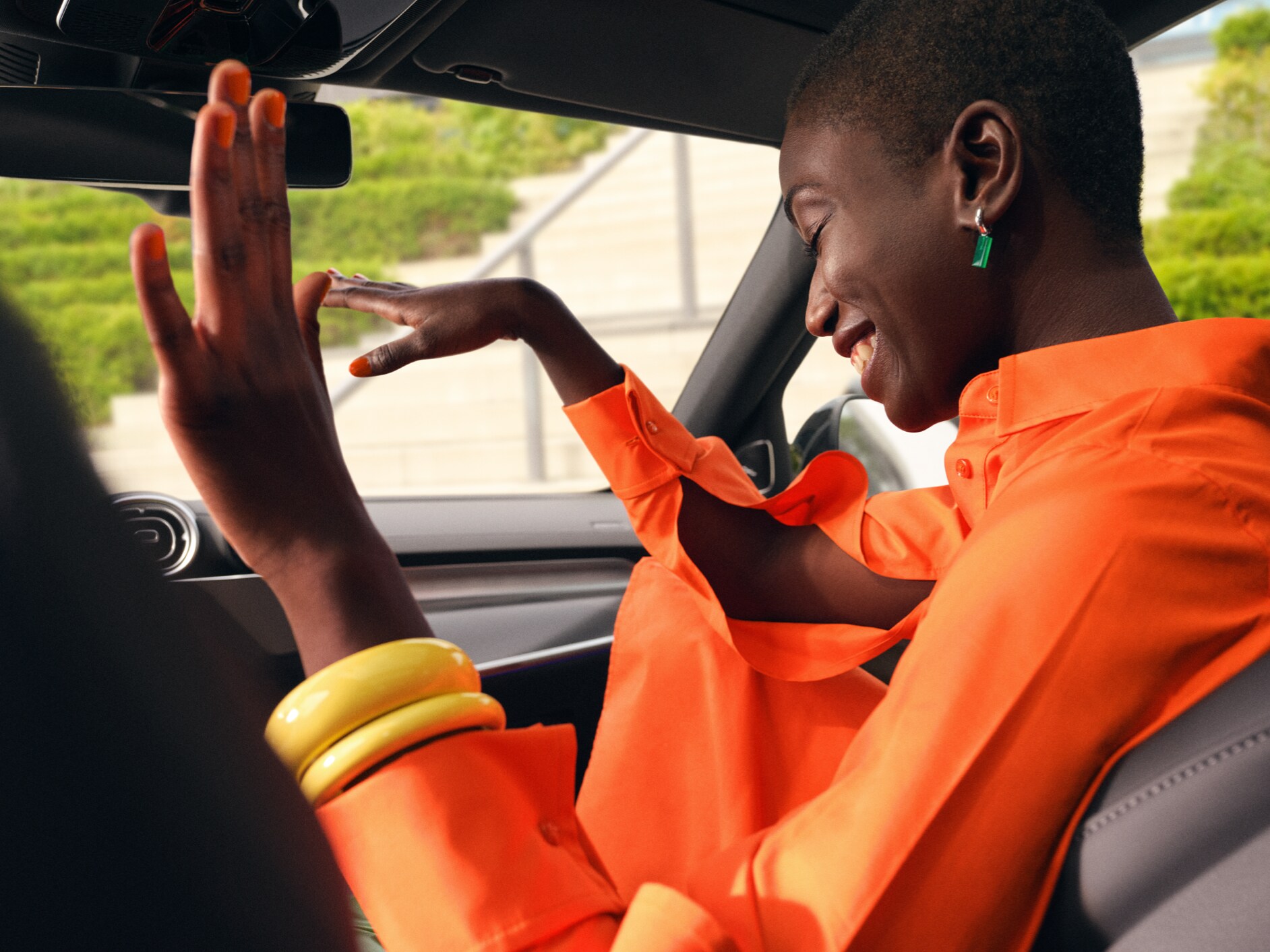 Uma mulher dança no banco do acompanhante do seu Mercedes-Benz ao som de música.