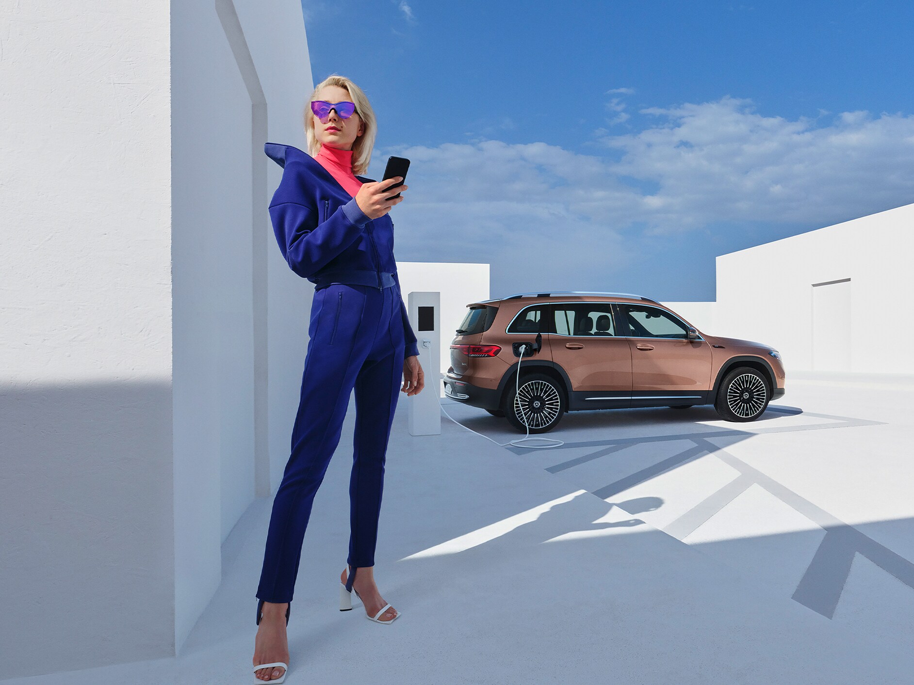 Uma mulher carrega confortavelmente o seu Mercedes-Benz numa estação de carregamento da IONITY.