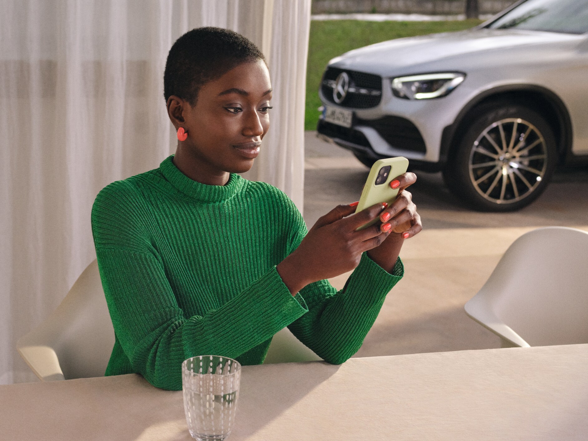 Uma mulher verifica o estado do seu veículo com o seu smartphone.