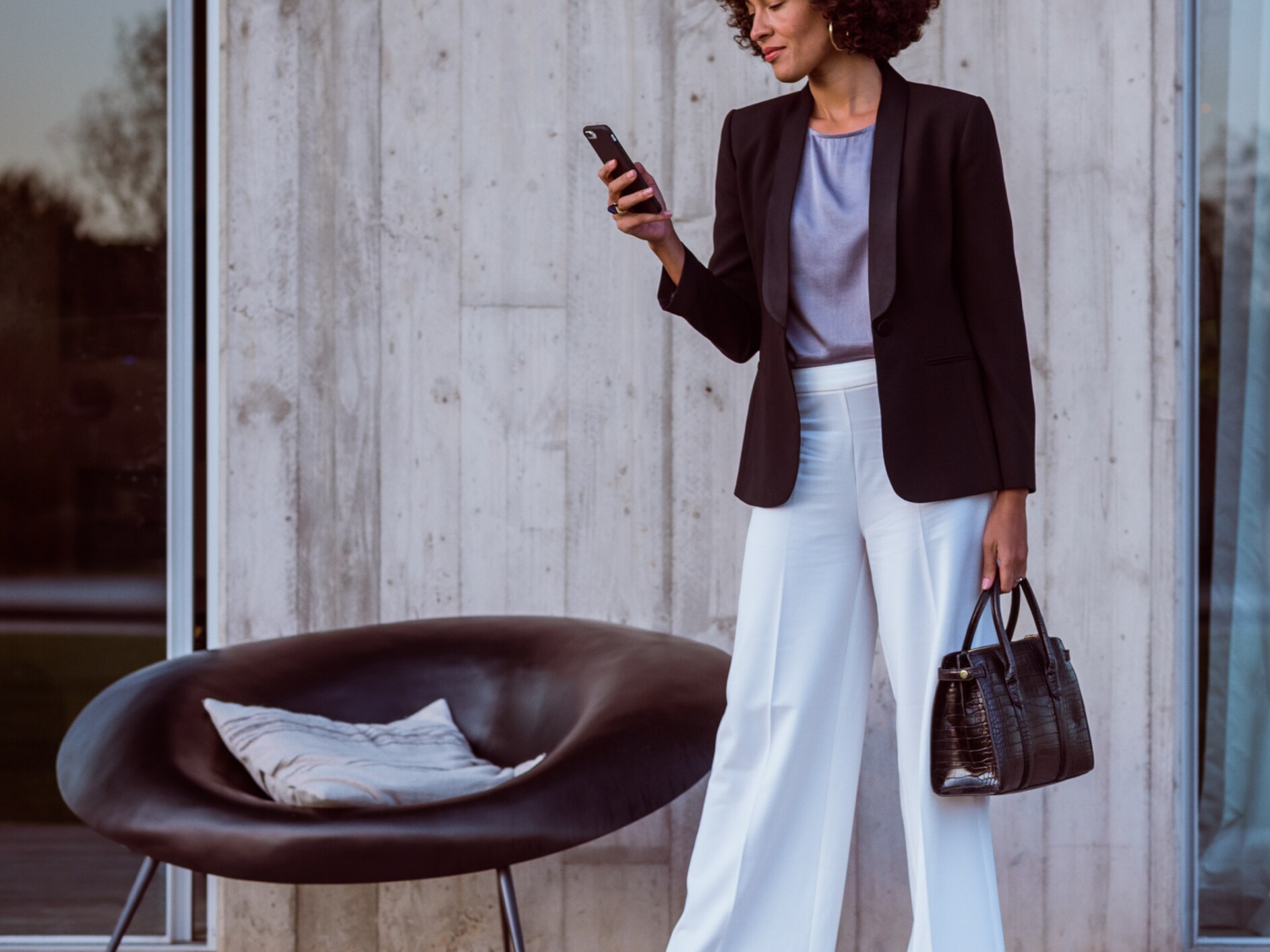 Uma mulher liga-se ao seu Mercedes-Benz através do smartphone, da aplicação Mercedes e da sua Mercedes me ID.