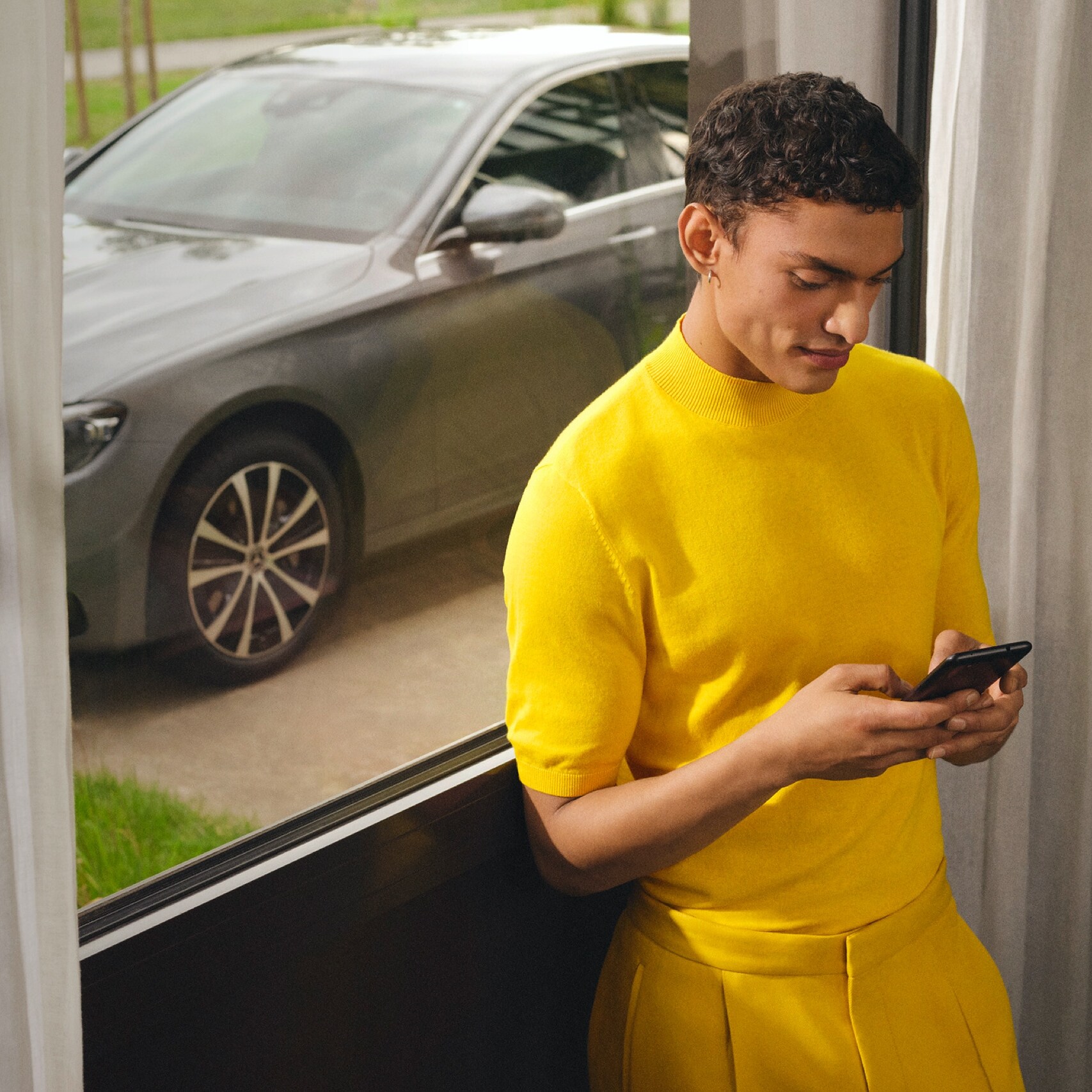 Um homem está ligado ao seu Mercedes-Benz através de extras digitais no smartphone.