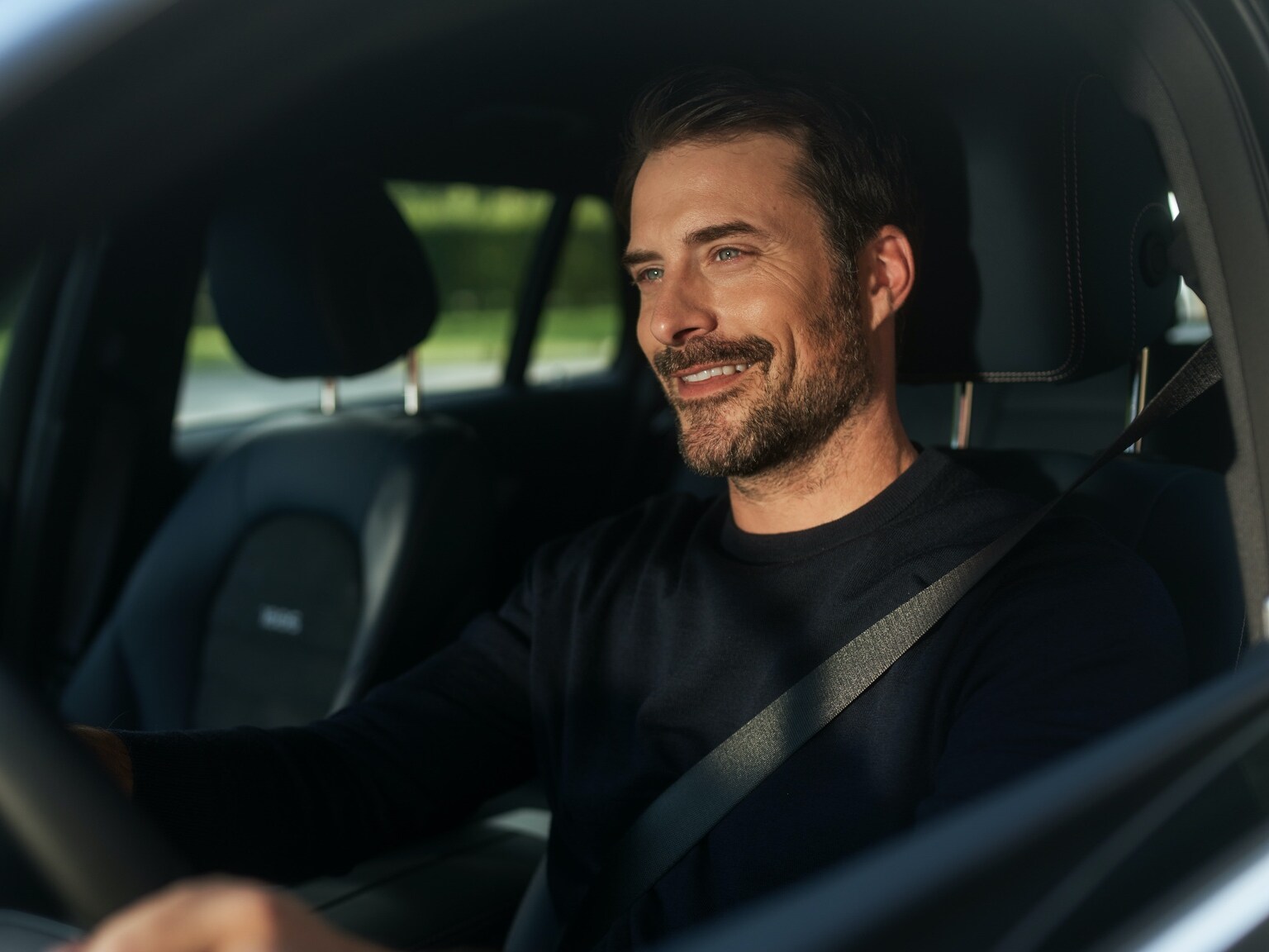 Um homem desfruta de Rádio Internet sem interrupções no seu Mercedes-Benz graças ao Pack Entretenimento.