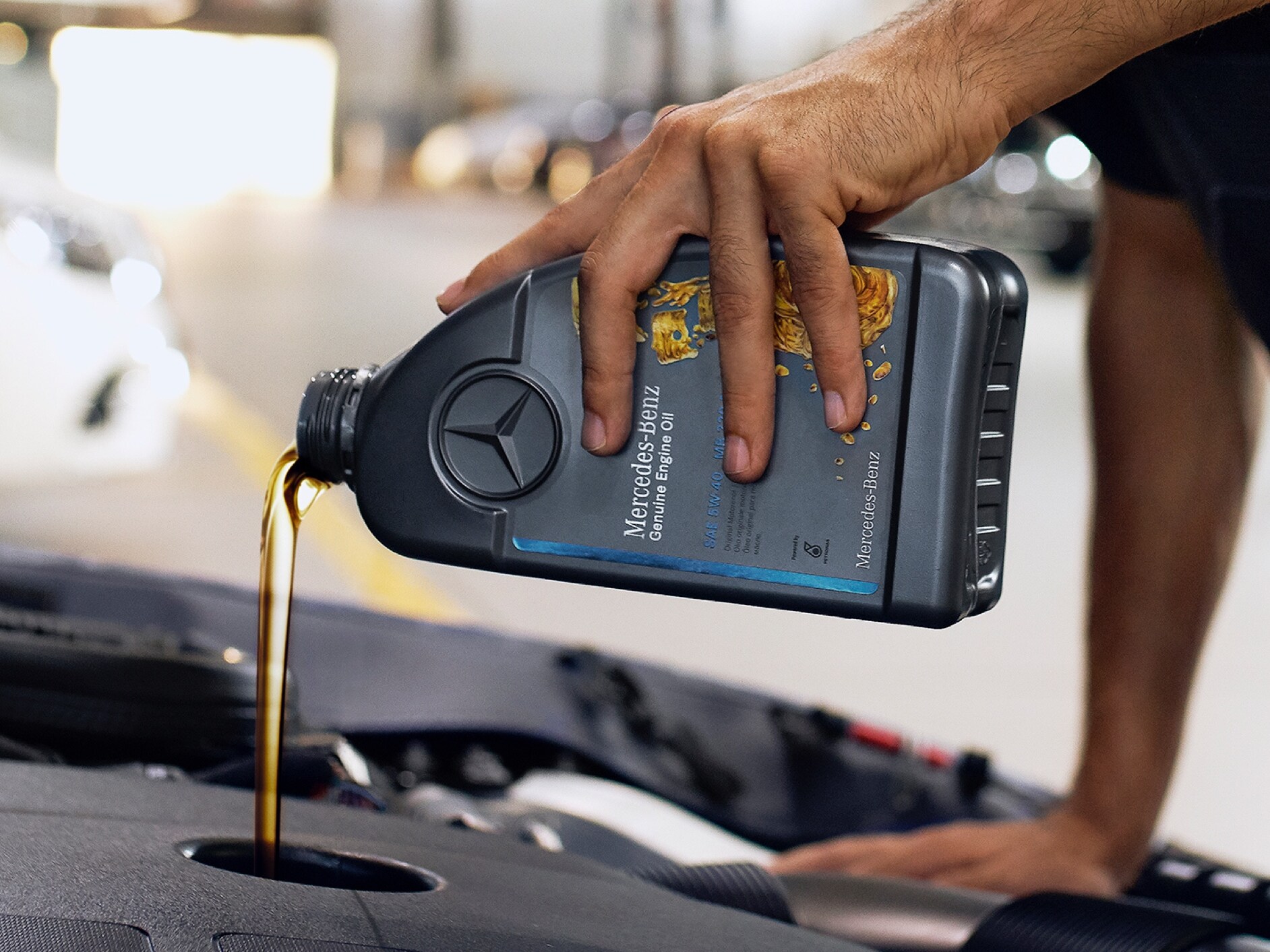 Uma pessoa deita óleo de motor no veículo Mercedes-Benz.