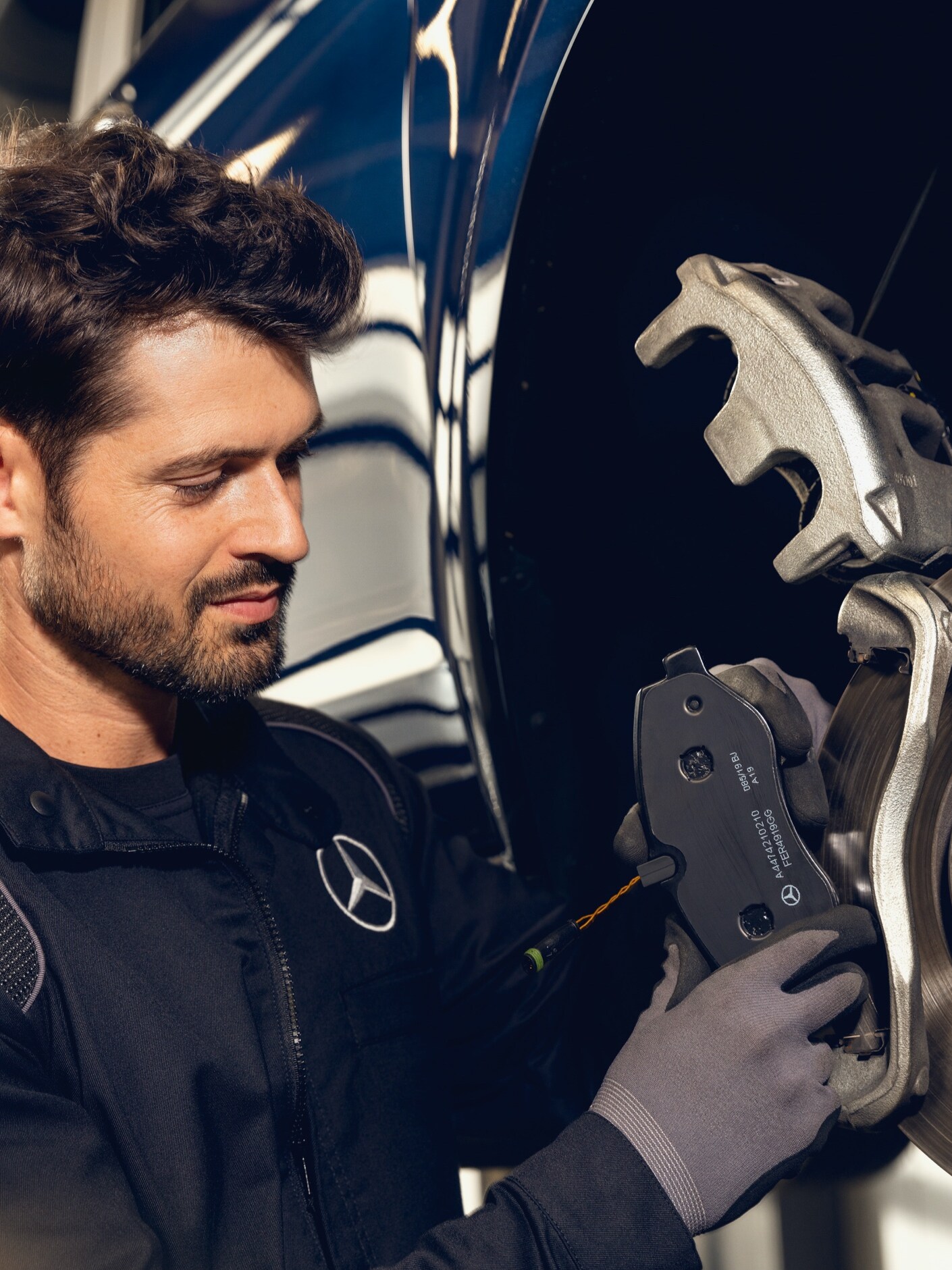 Um técnico da Mercedes-Benz inspeciona os travões de um veículo no banco de ensaio.