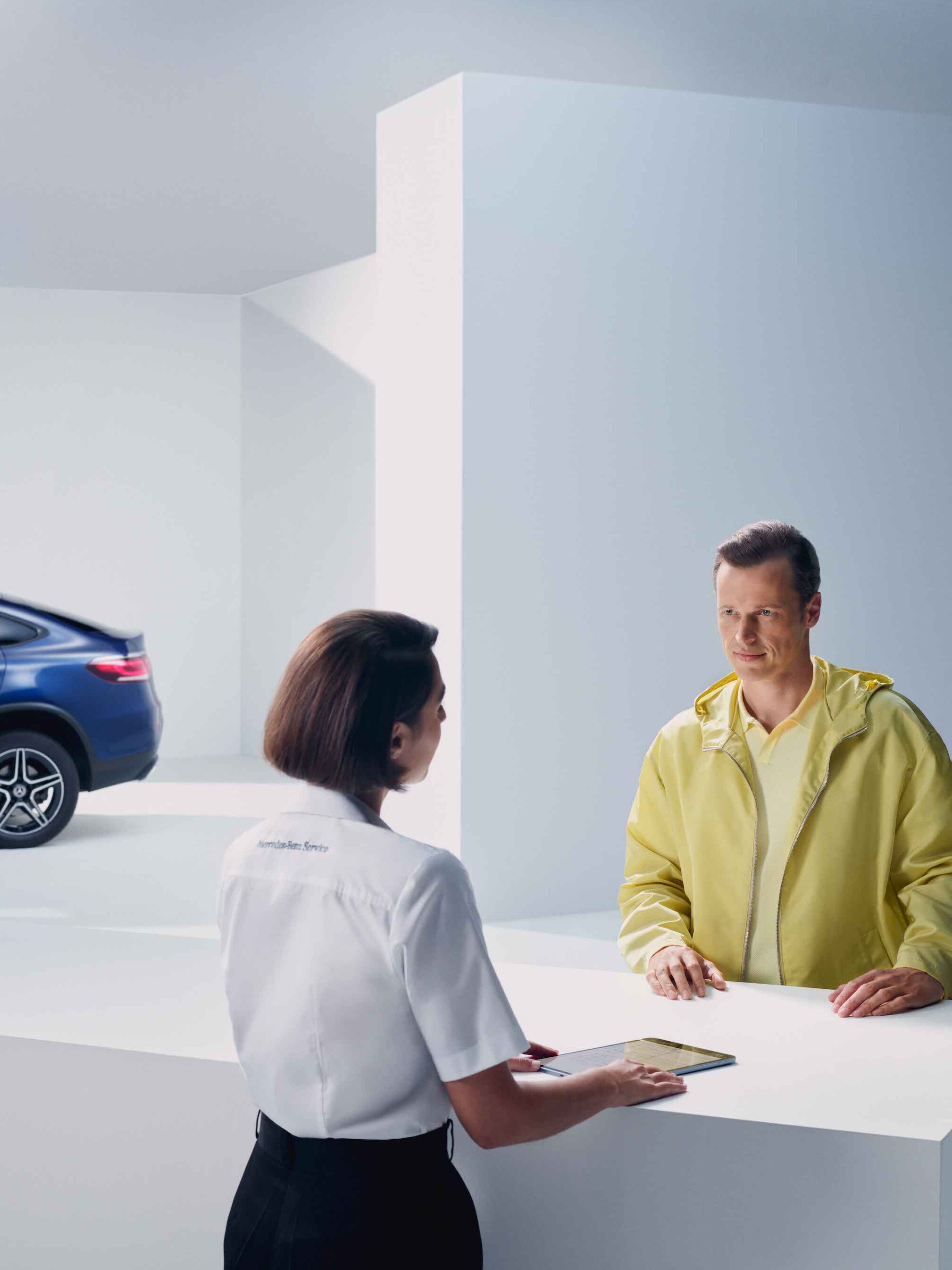 Um homem é aconselhado por uma funcionária da Mercedes-Benz.