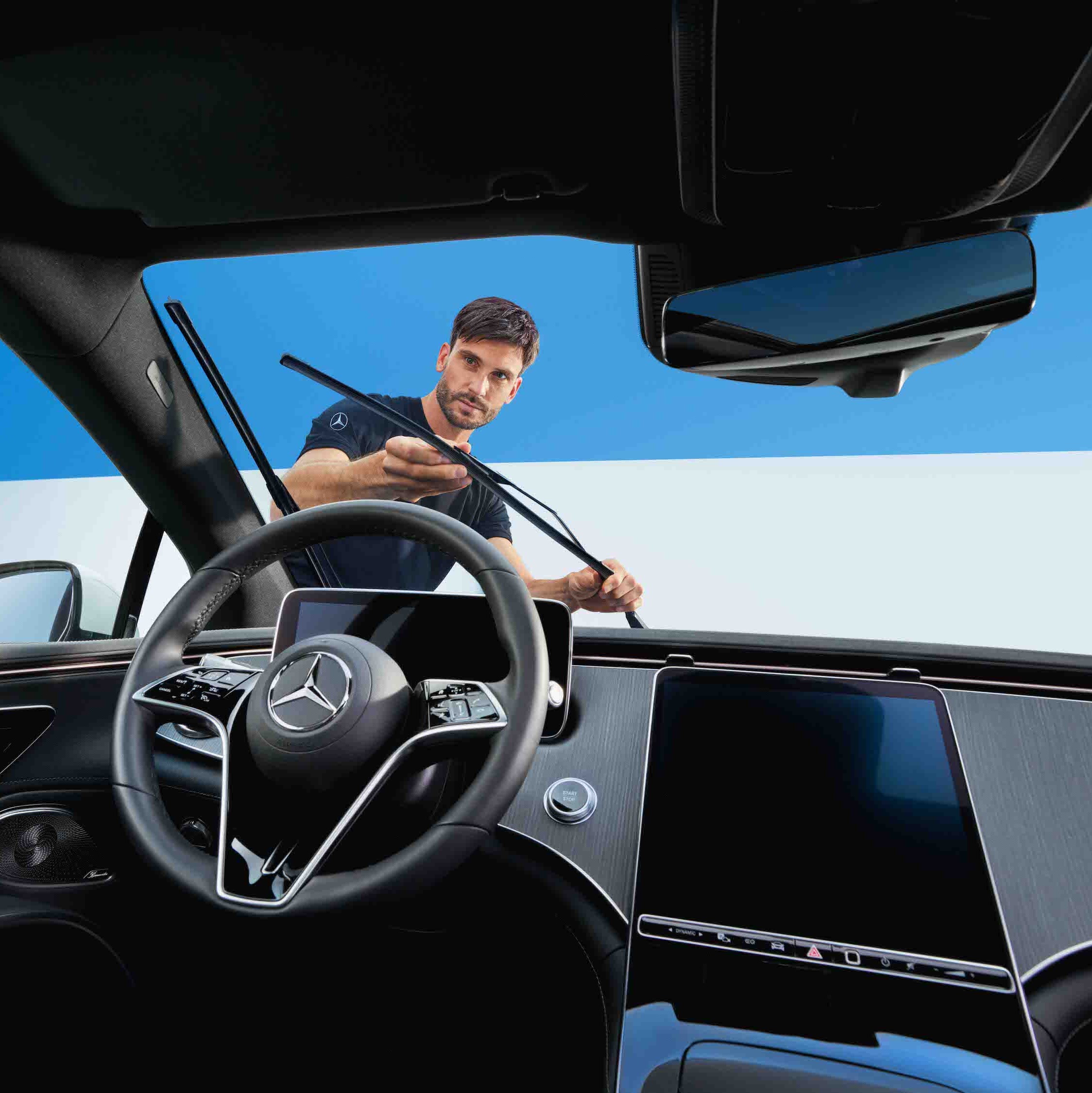 Um técnico da Mercedes-Benz substitui os limpa-vidros no veículo.