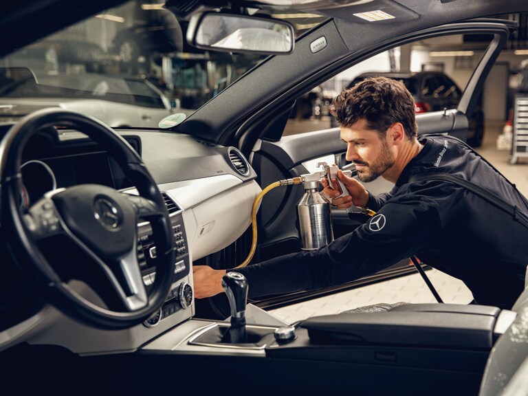 Um técnico da Mercedes-Benz realiza uma limpeza do ar-condicionado..