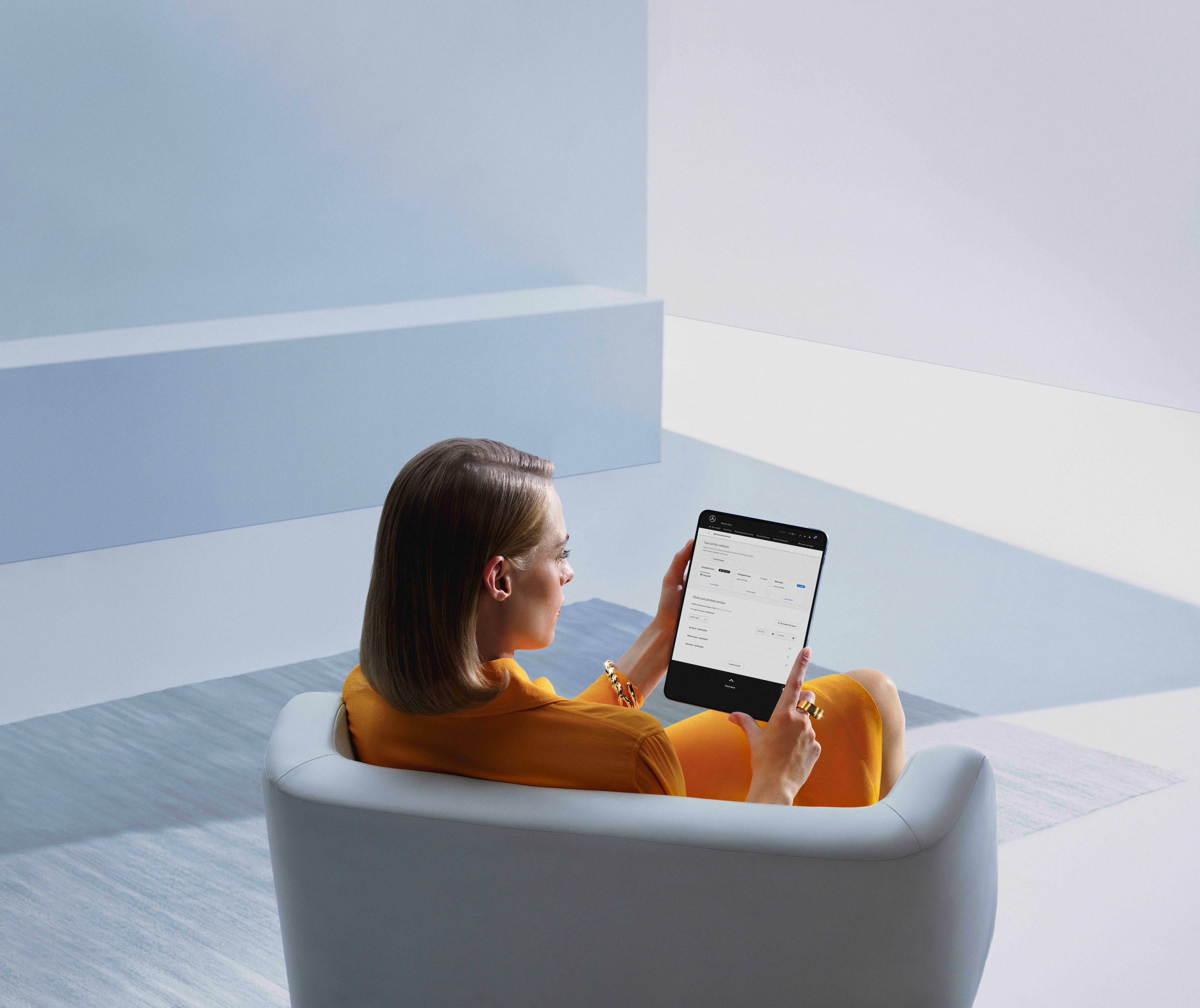 Relatório de serviço digital | Mercedes-Benz Uma mulher consulta seu relatório de serviço digital no tablet.