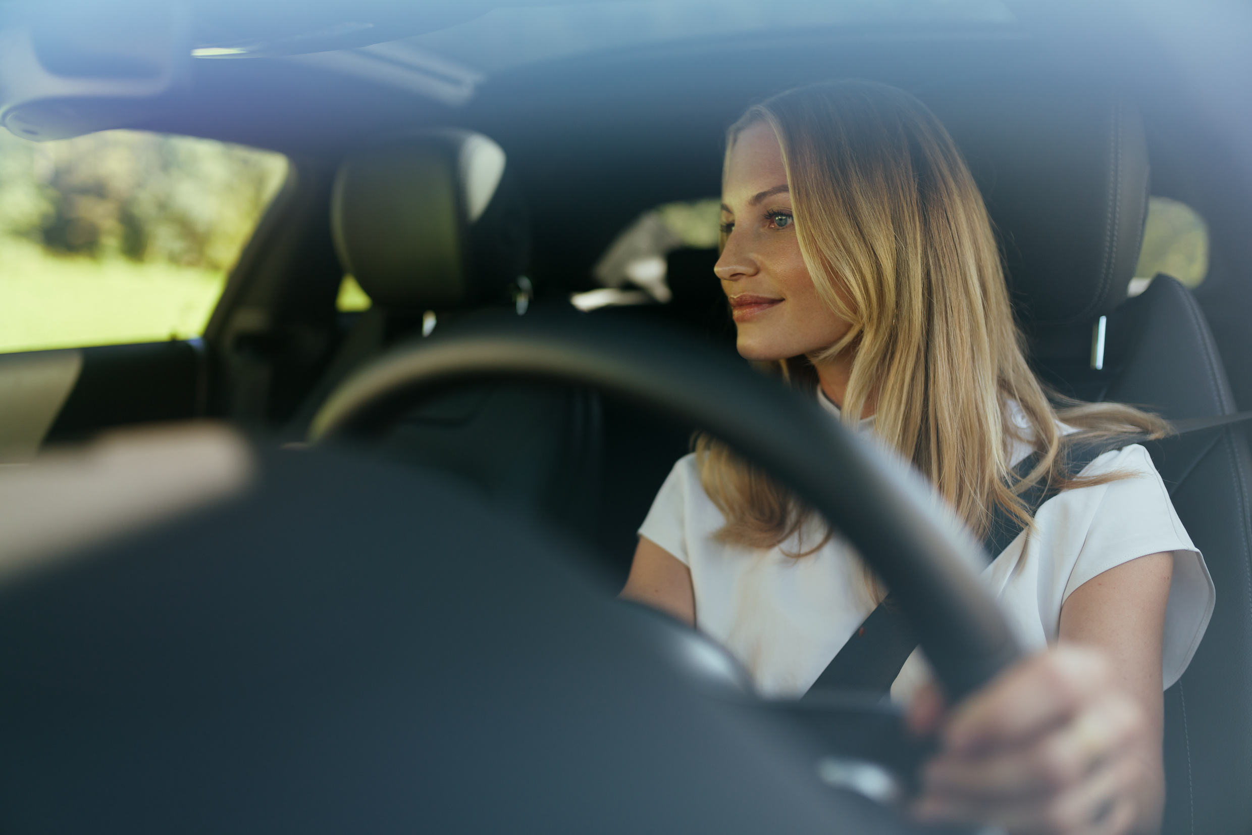 Tranquilidade com a garantia Mercedes-Benz. | Mercedes-Benz Uma mulher descontraída ao volante do seu Mercedes.