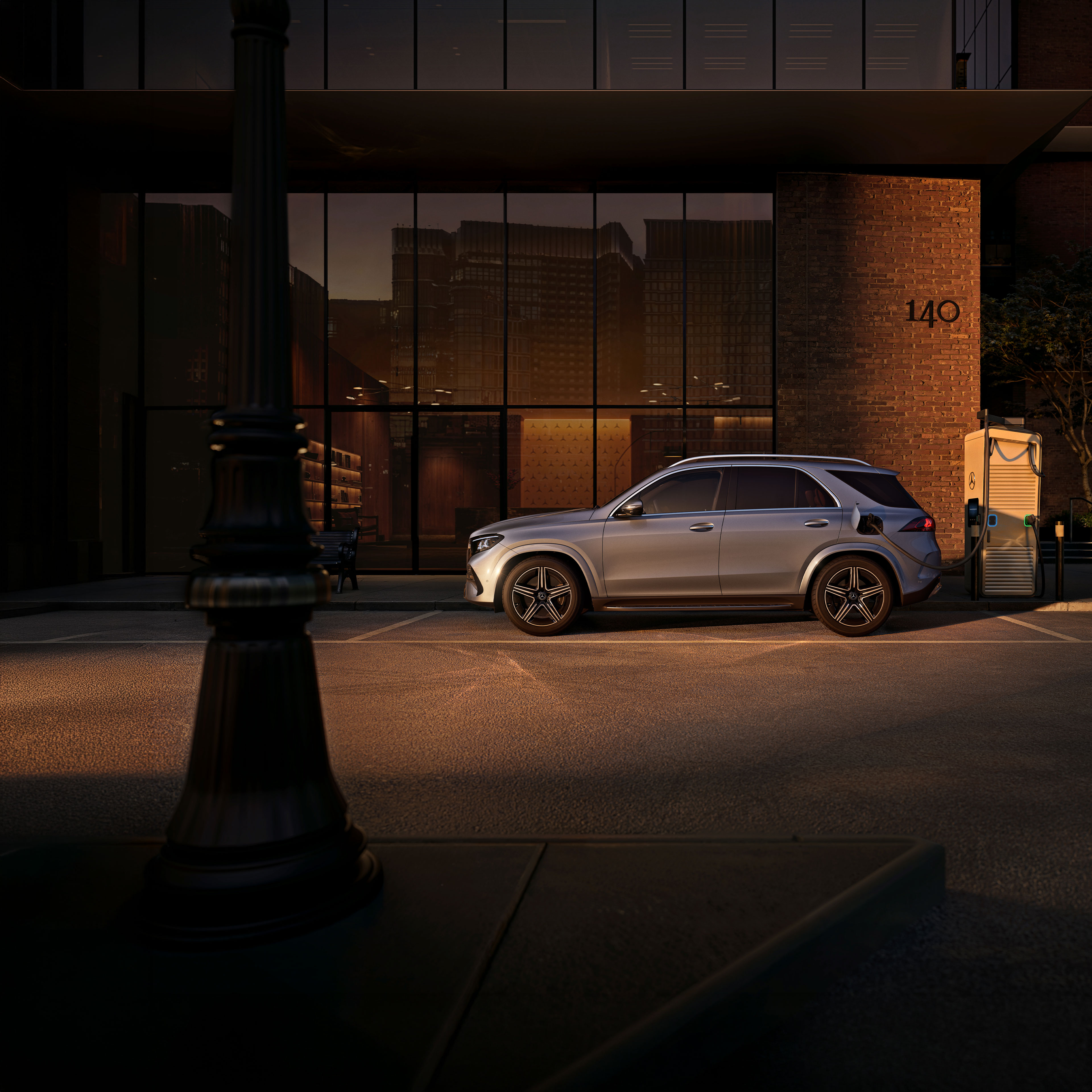 Híbridos plug-in | Mercedes-Benz O SUV Mercedes-Benz GLE numa foto lateral em frente a uma casa grande.