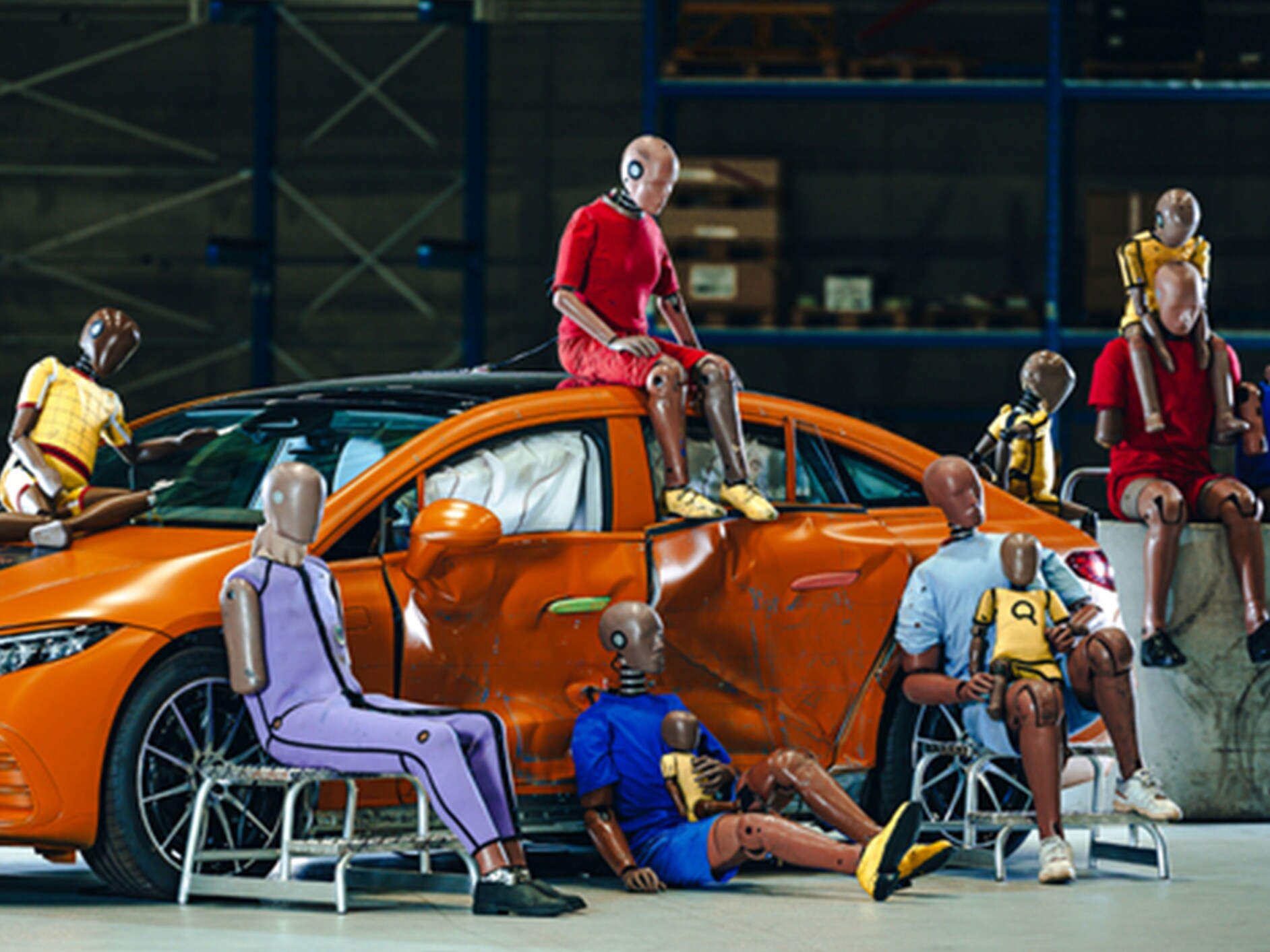 Vários bonecos de teste de colisão sentados em cima e à volta de um carro Mercedes-Benz.
