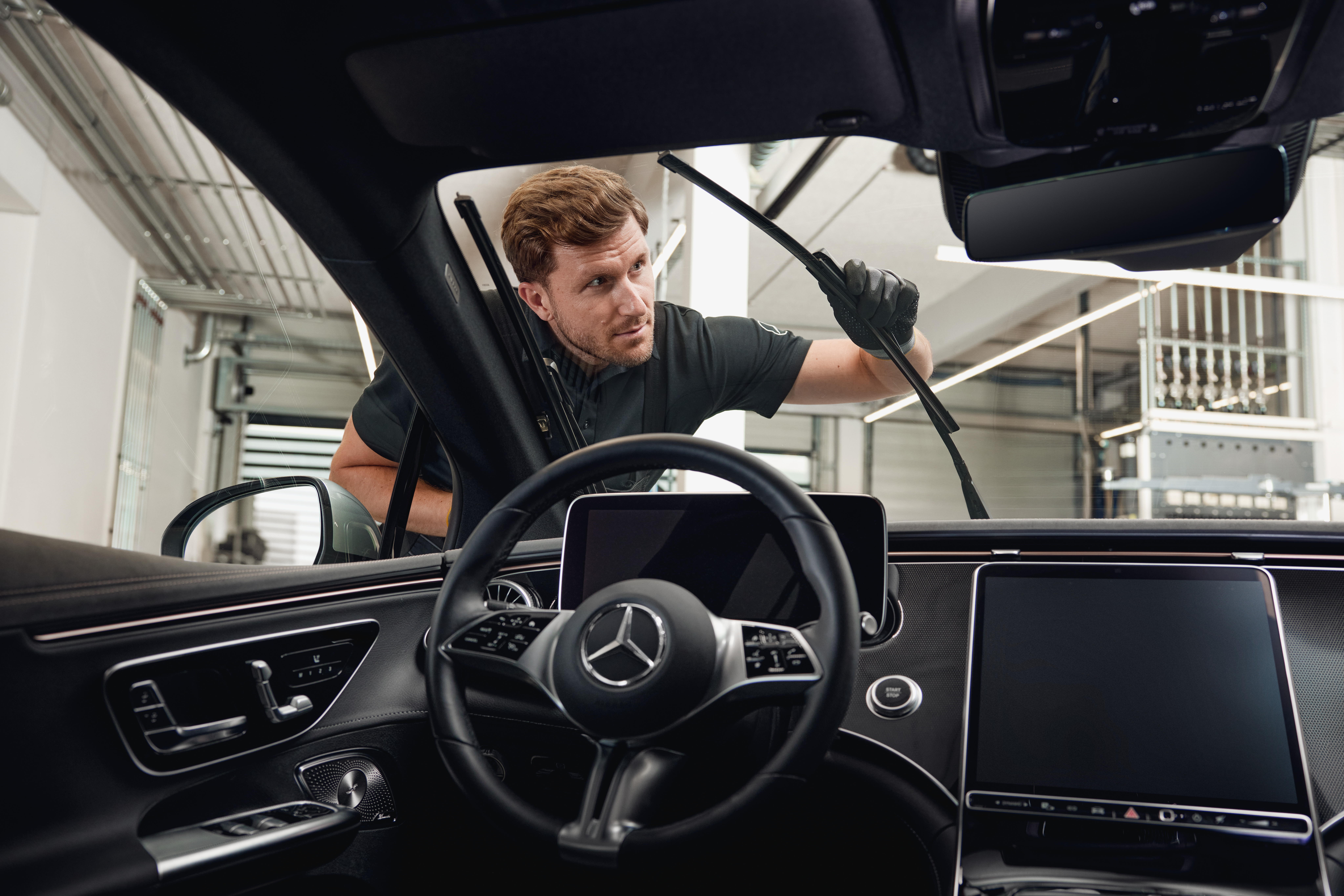 Escovas do limpa-vidros originais Mercedes-Benz Vista interior de um veículo Mercedes-Benz com um técnico a trocar as escovas do limpa-vidros originais.