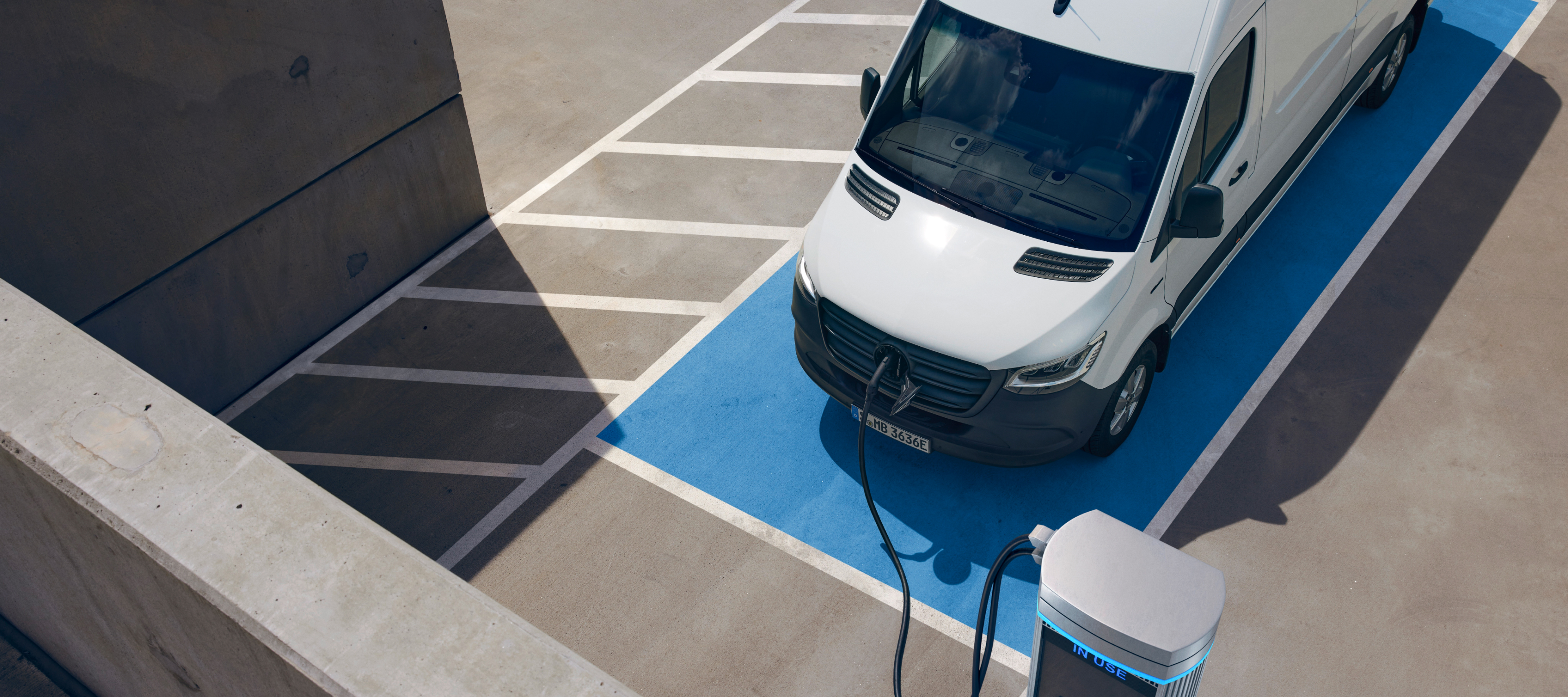Comparação de veículos | eSprinter Furgão | Mercedes-Benz O Mercedes-Benz eSprinter Furgão numa estação de carregamento.