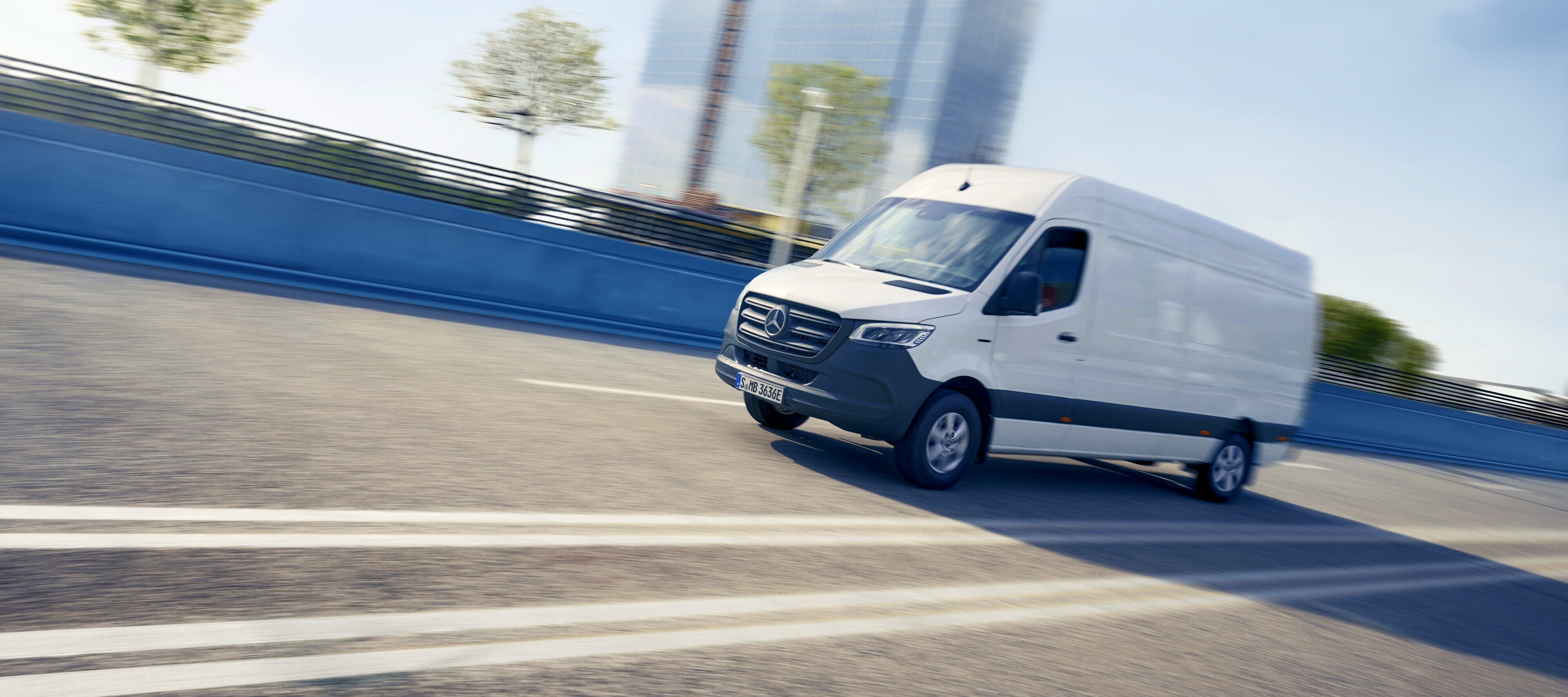 Comparação de veículos | eSprinter Furgão | Mercedes-Benz O eSprinter Furgão da Mercedes-Benz em frente a materiais de construção.