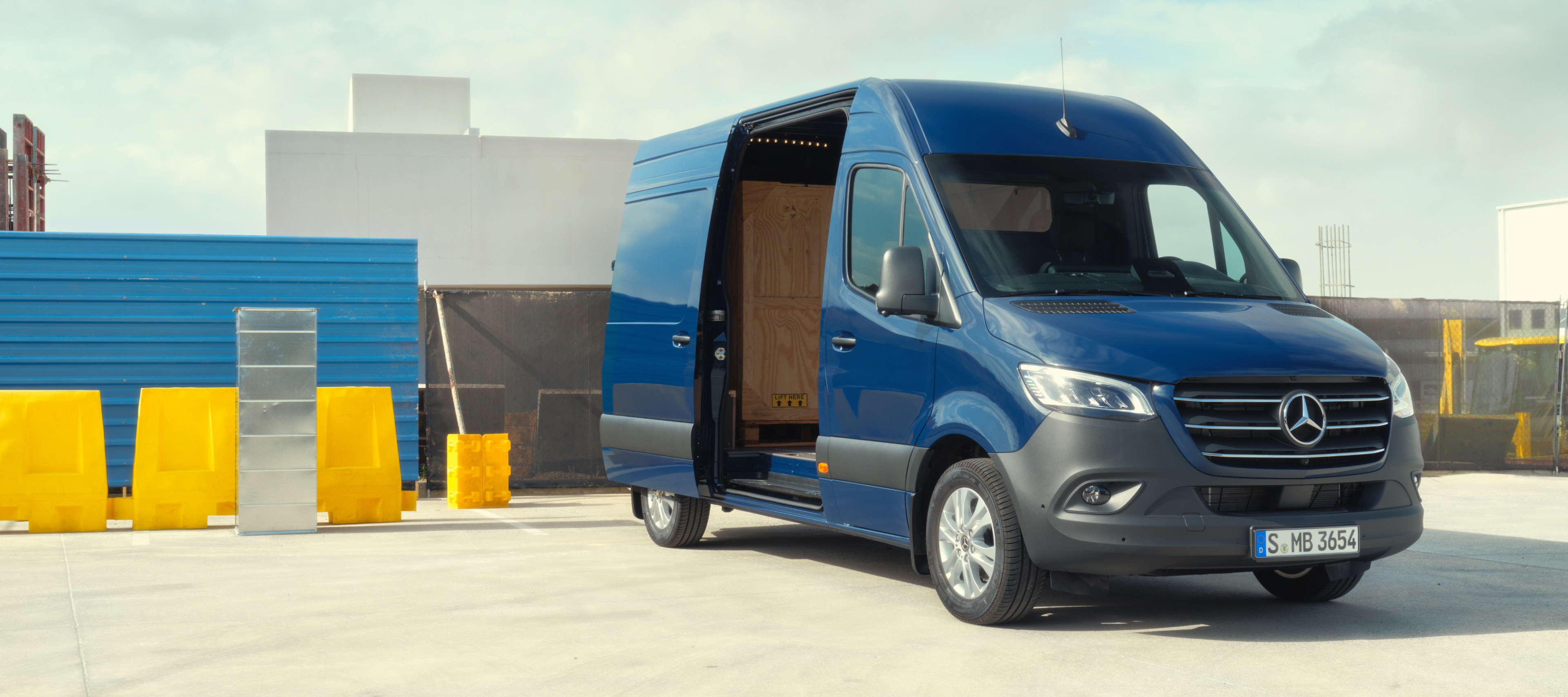 Comparação de veículos | Sprinter Furgão | Mercedes-Benz O Sprinter Furgão da Mercedes-Benz em frente a materiais de construção.