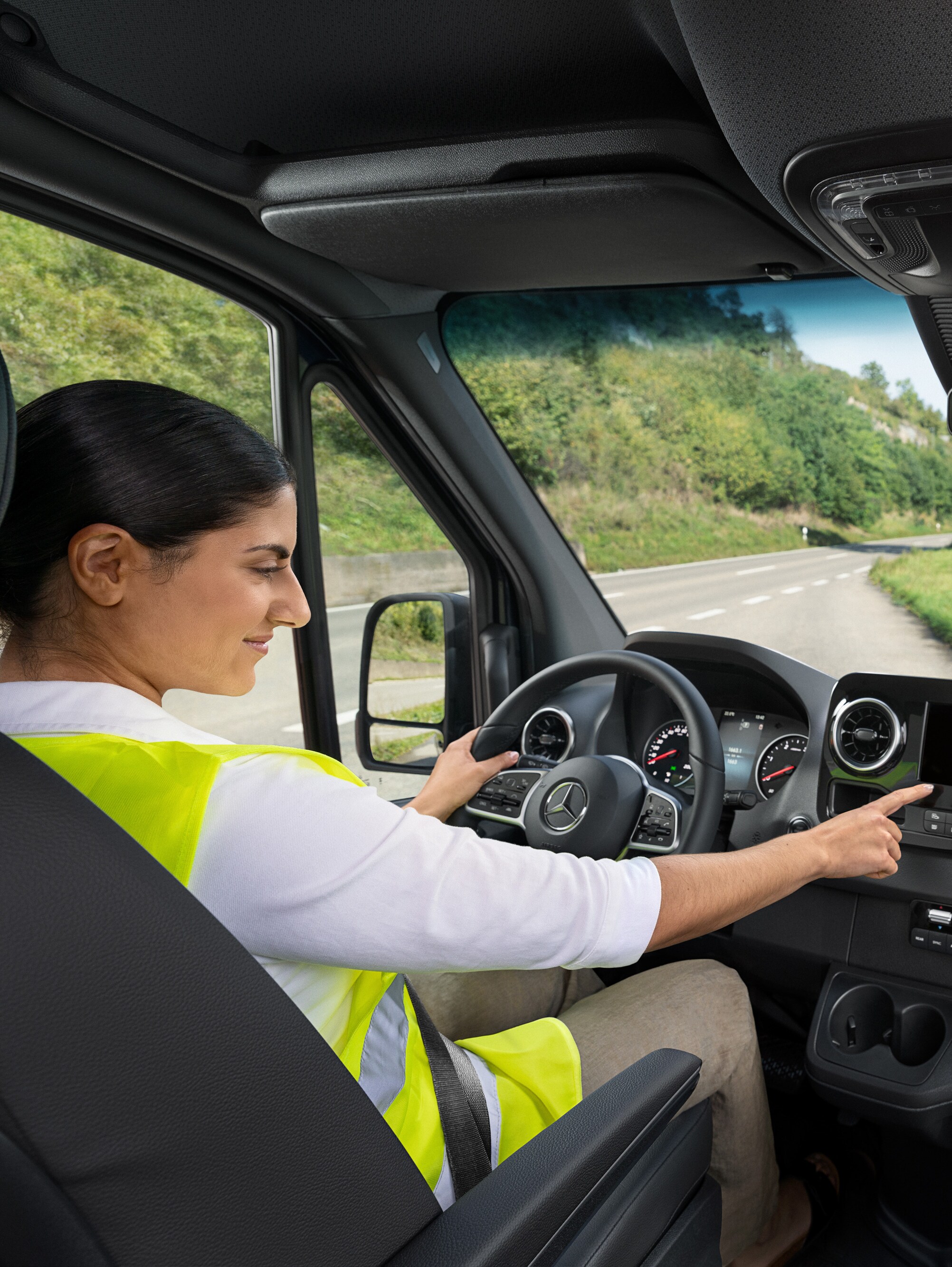 A condutora de um Mercedes-Benz Sprinter liga para a linha direta Mercedes-Benz Service24h através do menu de bordo se tiver um problema.