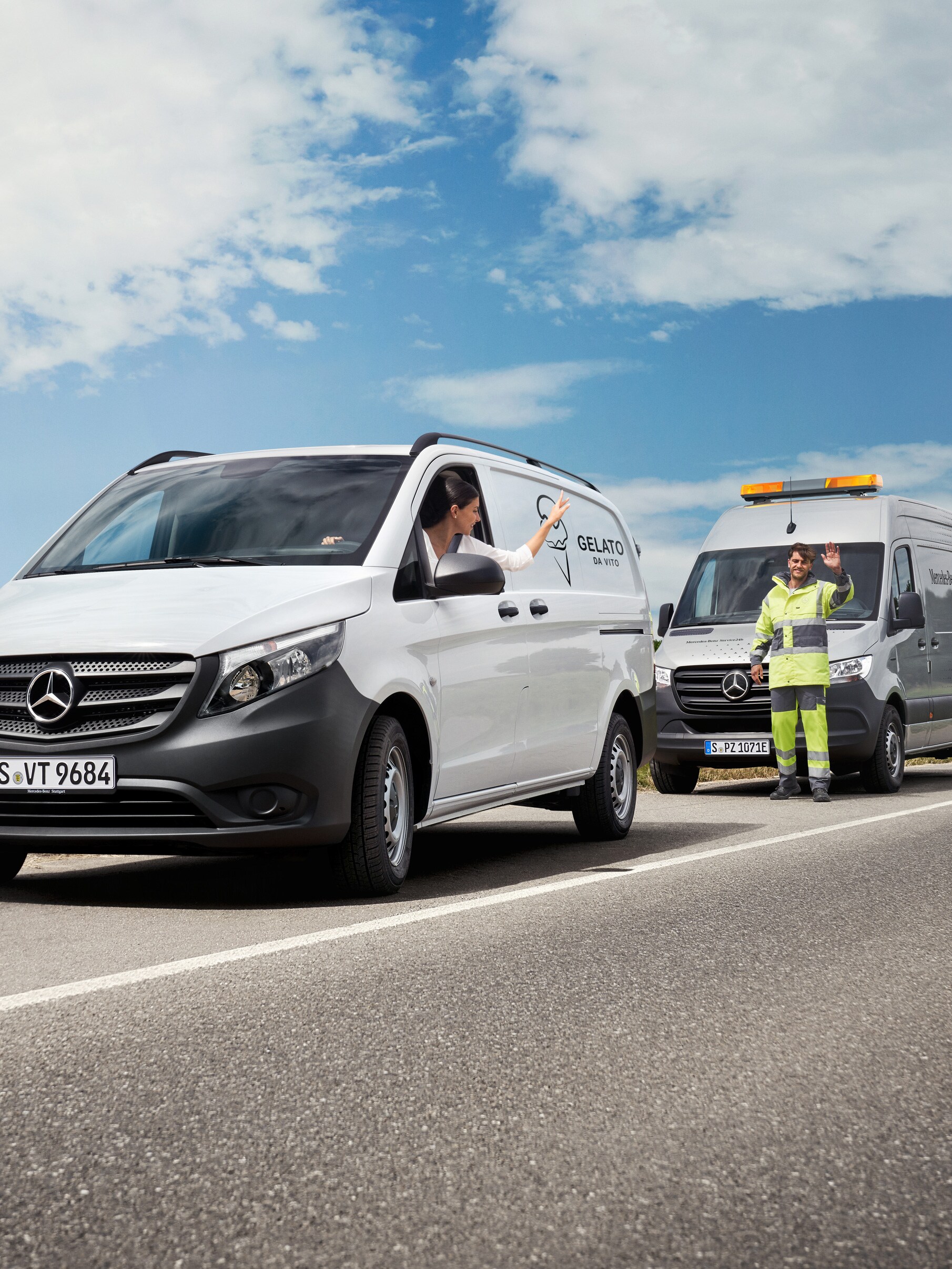 Uma pessoa num veículo comercial ligeiro Mercedes-Benz Vito branco acena a um técnico de assistência estacionado na berma da estrada.