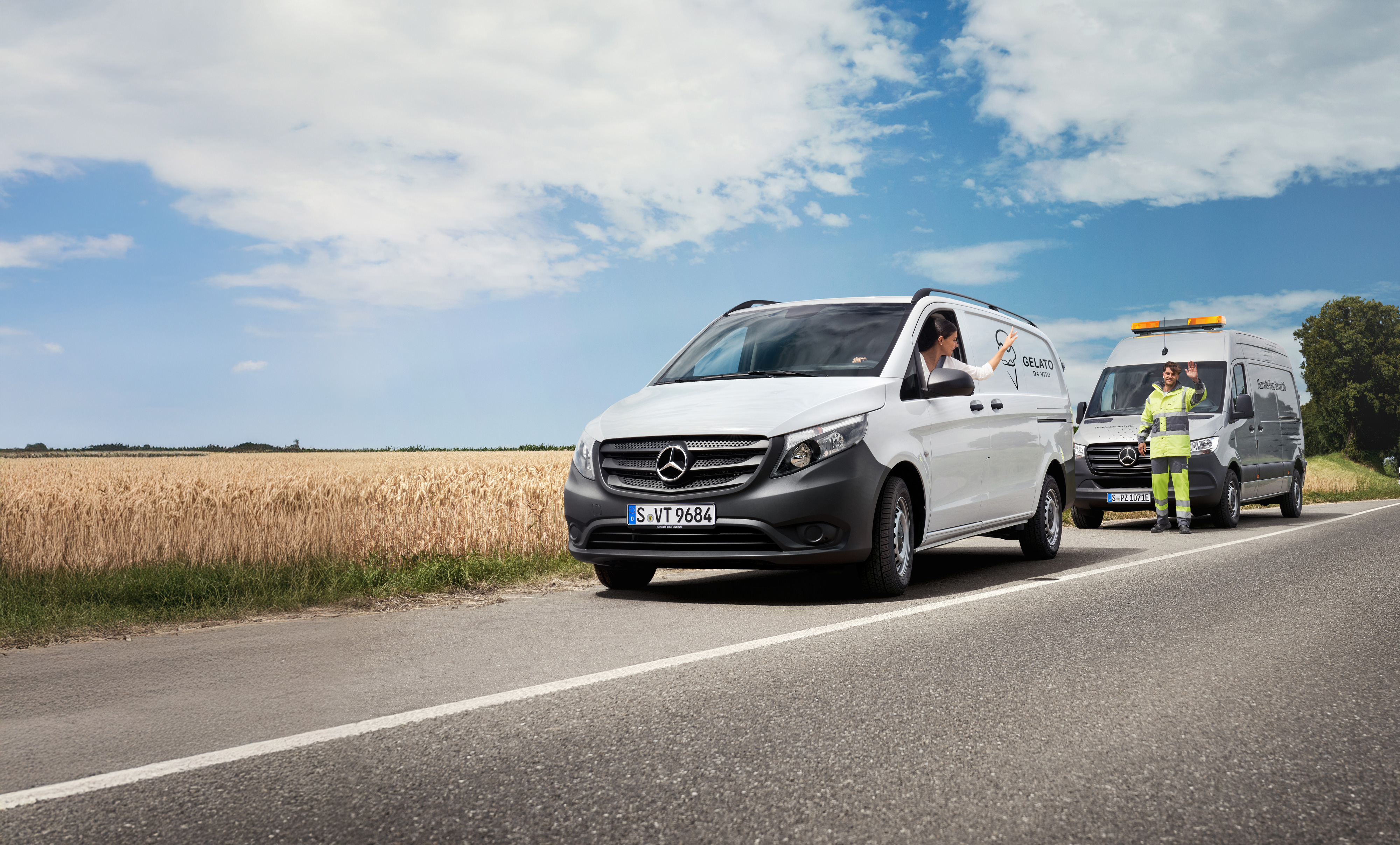 Mercedes-Benz | Conforto | MobiloVan Uma mulher sentada num Mercedes-Benz Vito branco acena a um técnico de manutenção da Mercedes-Benz na berma da estrada.