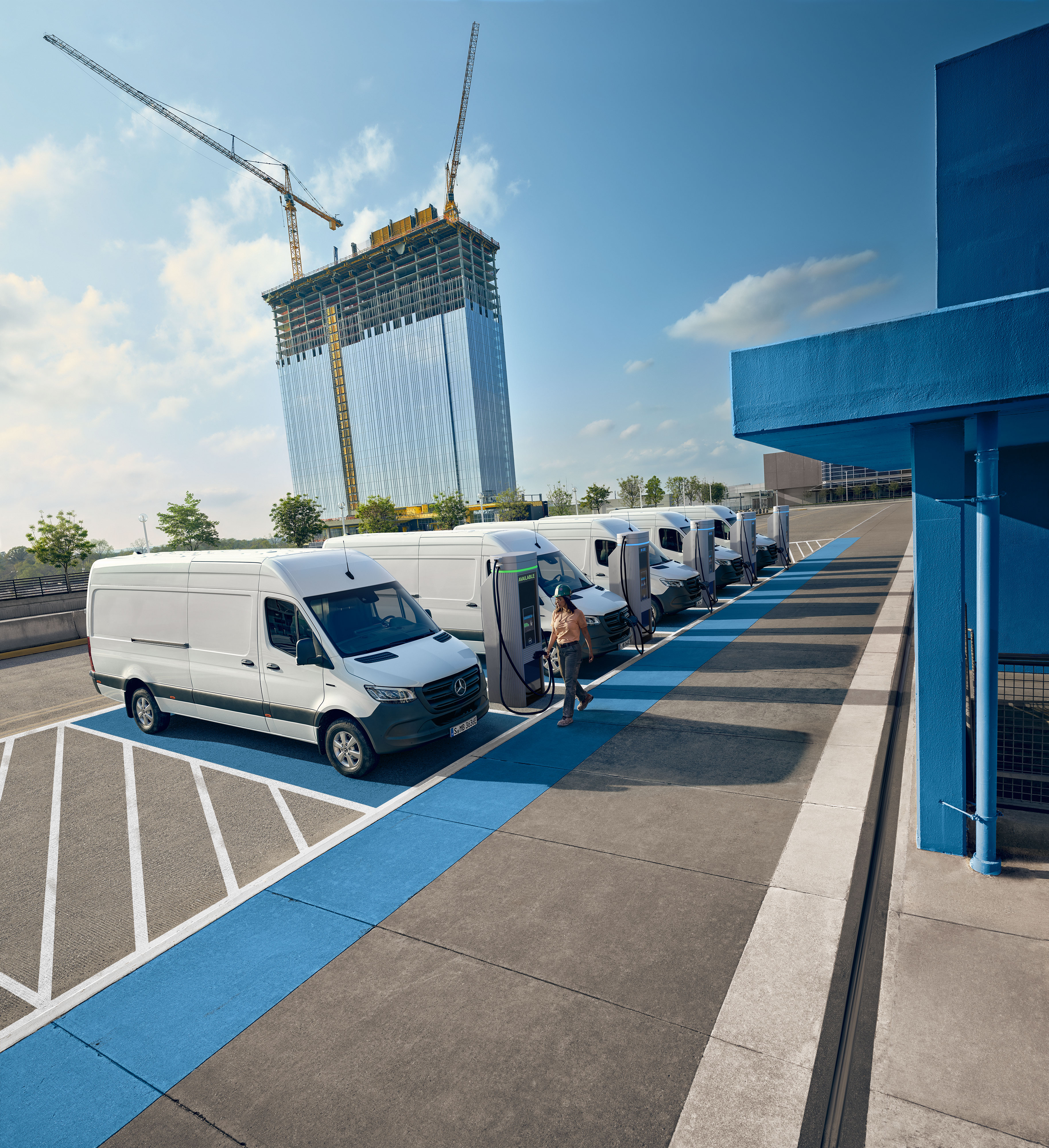 Mercedes-Benz | Assistência de veículos comerciais ligeiros | Assistência em Viagem Vários veículos comerciais ligeiros Mercedes-Benz Sprinter brancos a carregar em estações de carregamento.