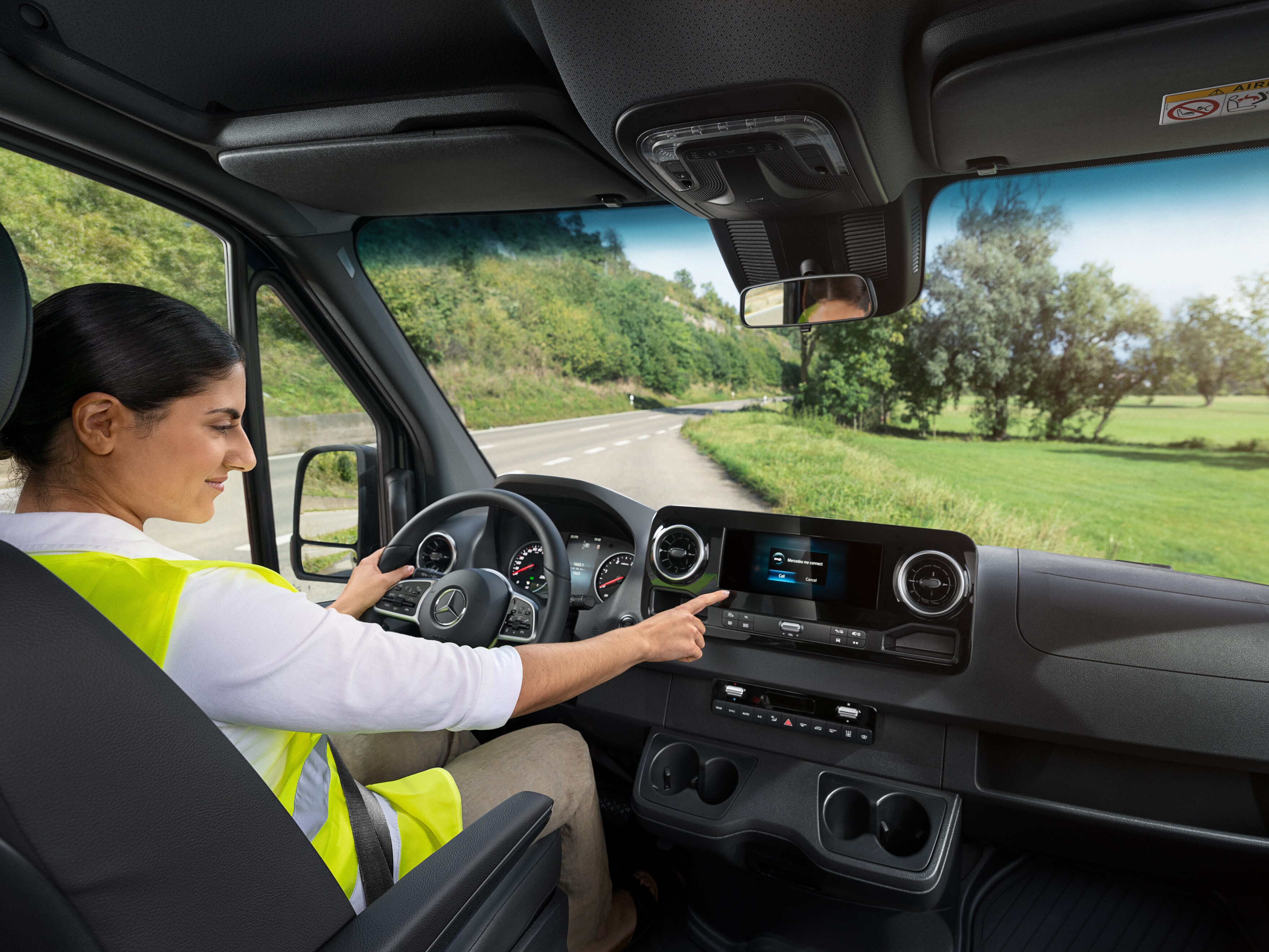 Condutora verifica o display de bordo do seu veículo comercial ligeiro Mercedes-Benz.