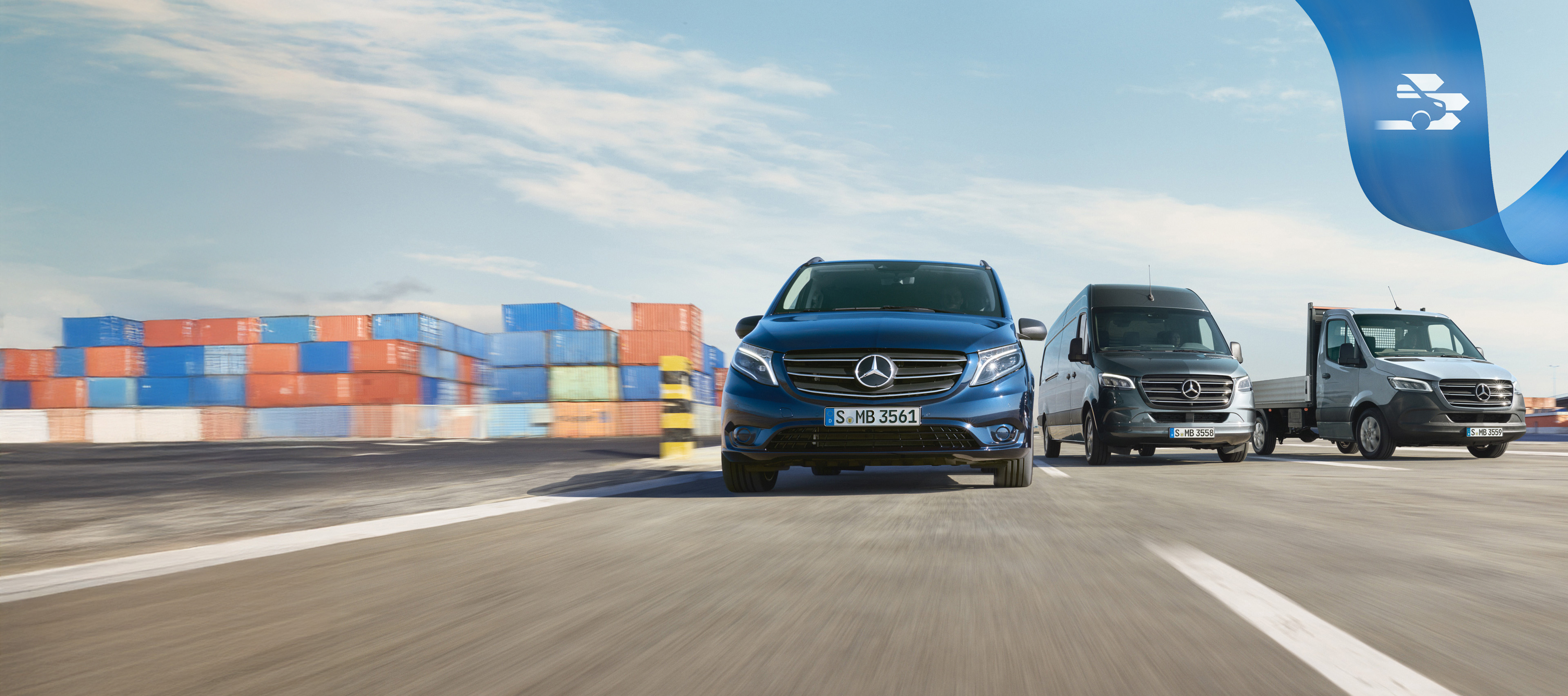 Mercedes-Benz | Conforto Mobilovan Uma série de veículos comerciais ligeiros Mercedes-Benz a circular na estrada com contentores de transporte em segundo plano.