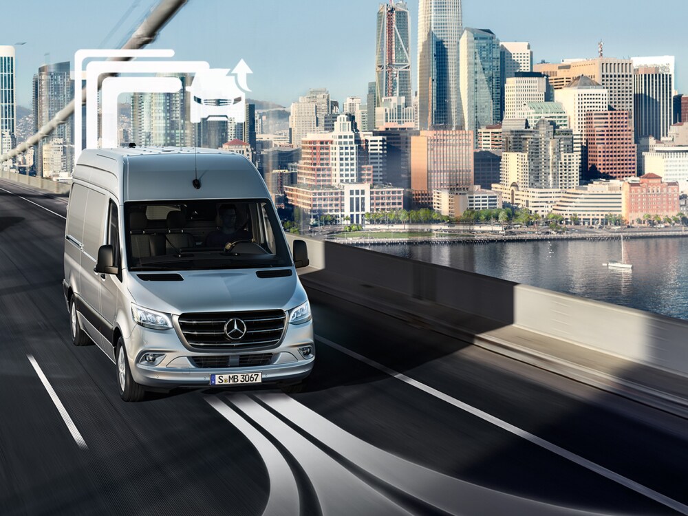 Um veículo comercial ligeiro Mercedes-Benz Vans atravessa uma ponte com várias faixas durante o dia.
