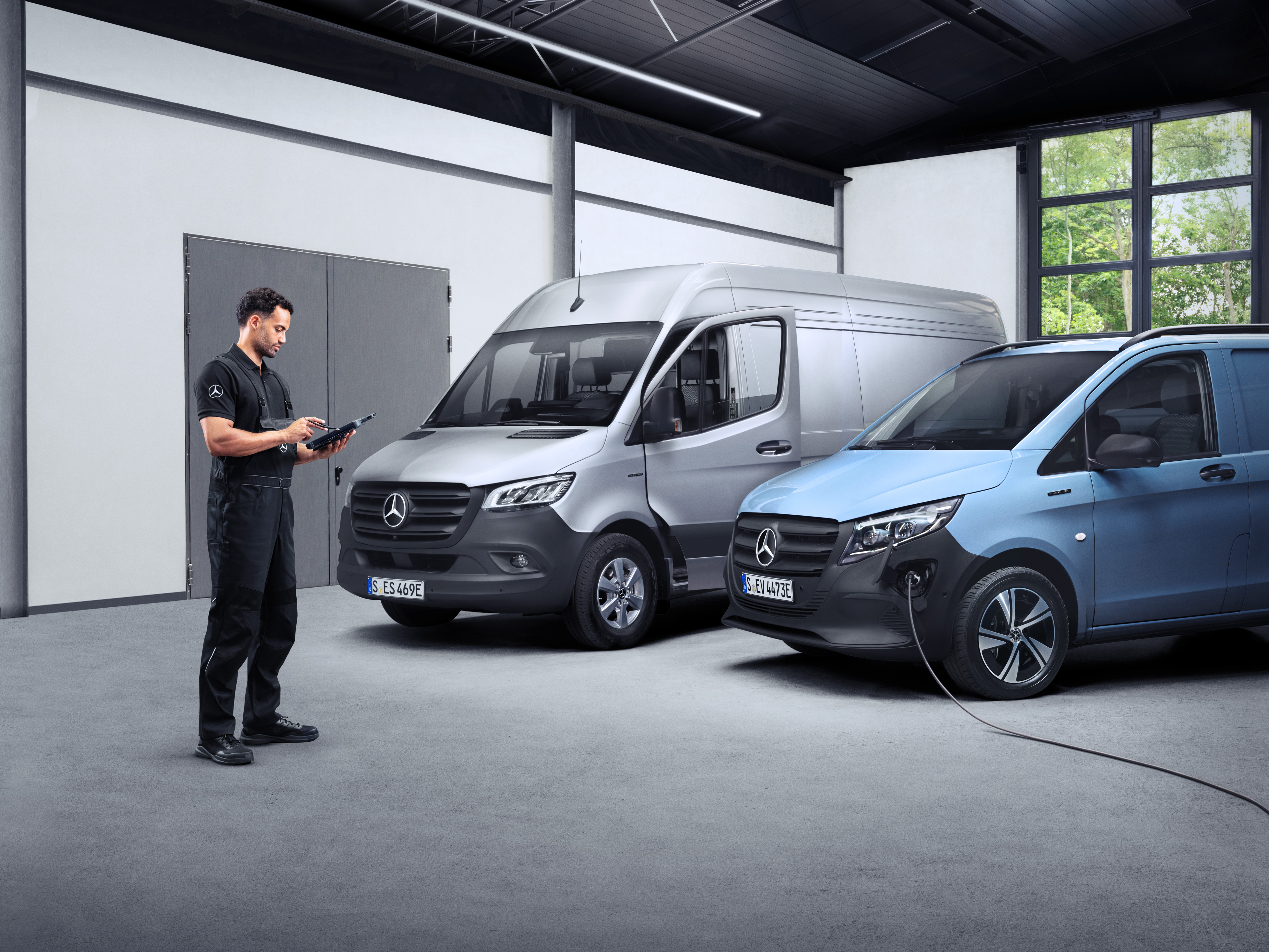 Mercedes-Benz | ServiceCare veículos comerciais ligeiros Um técnico à frente de duas eVans num tablet