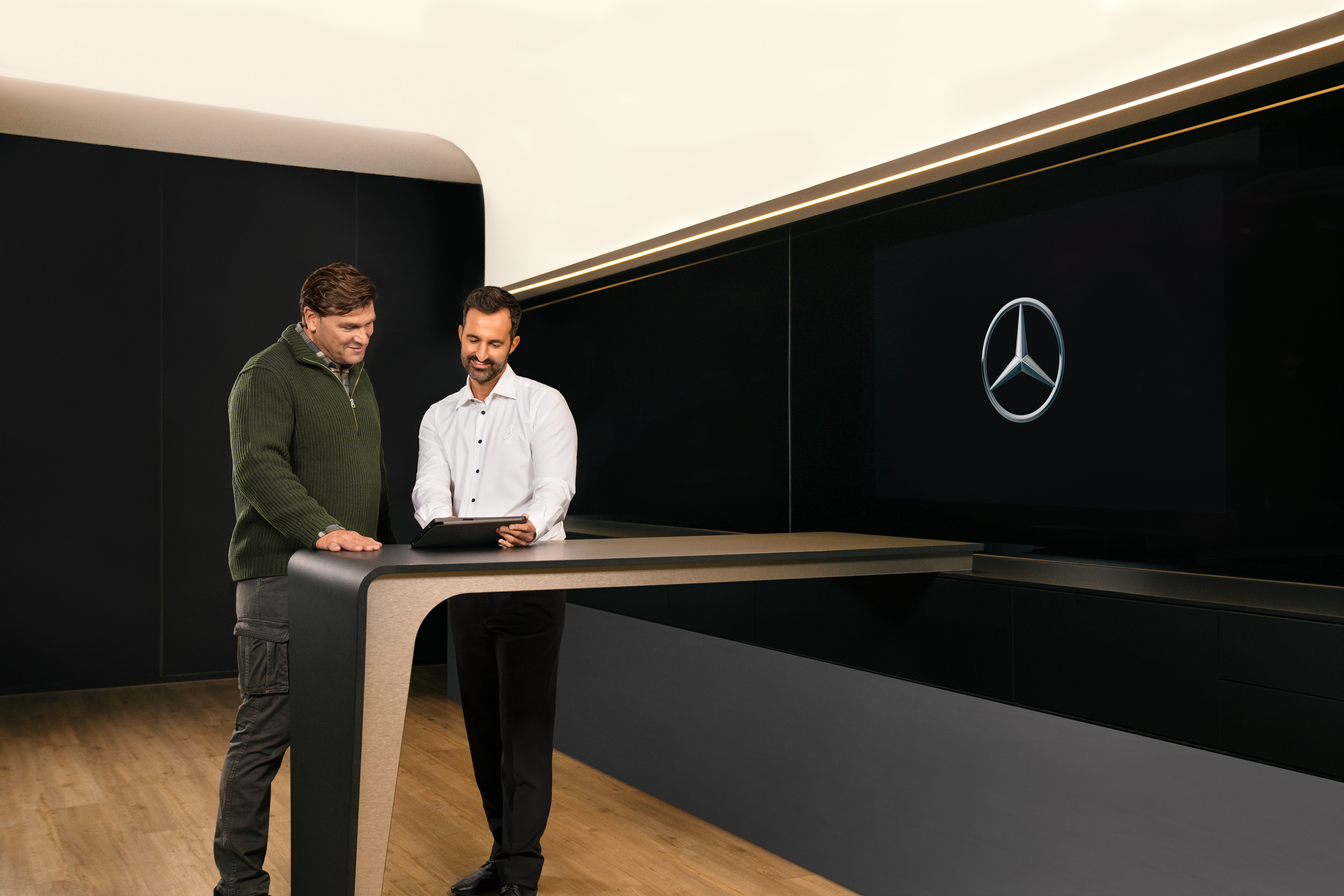 Mercedes-Benz | Visão geral dos serviços | ServiceCare Dois homens discutem o serviço de veículos comerciais da Mercedes-Benz através de um tablet.