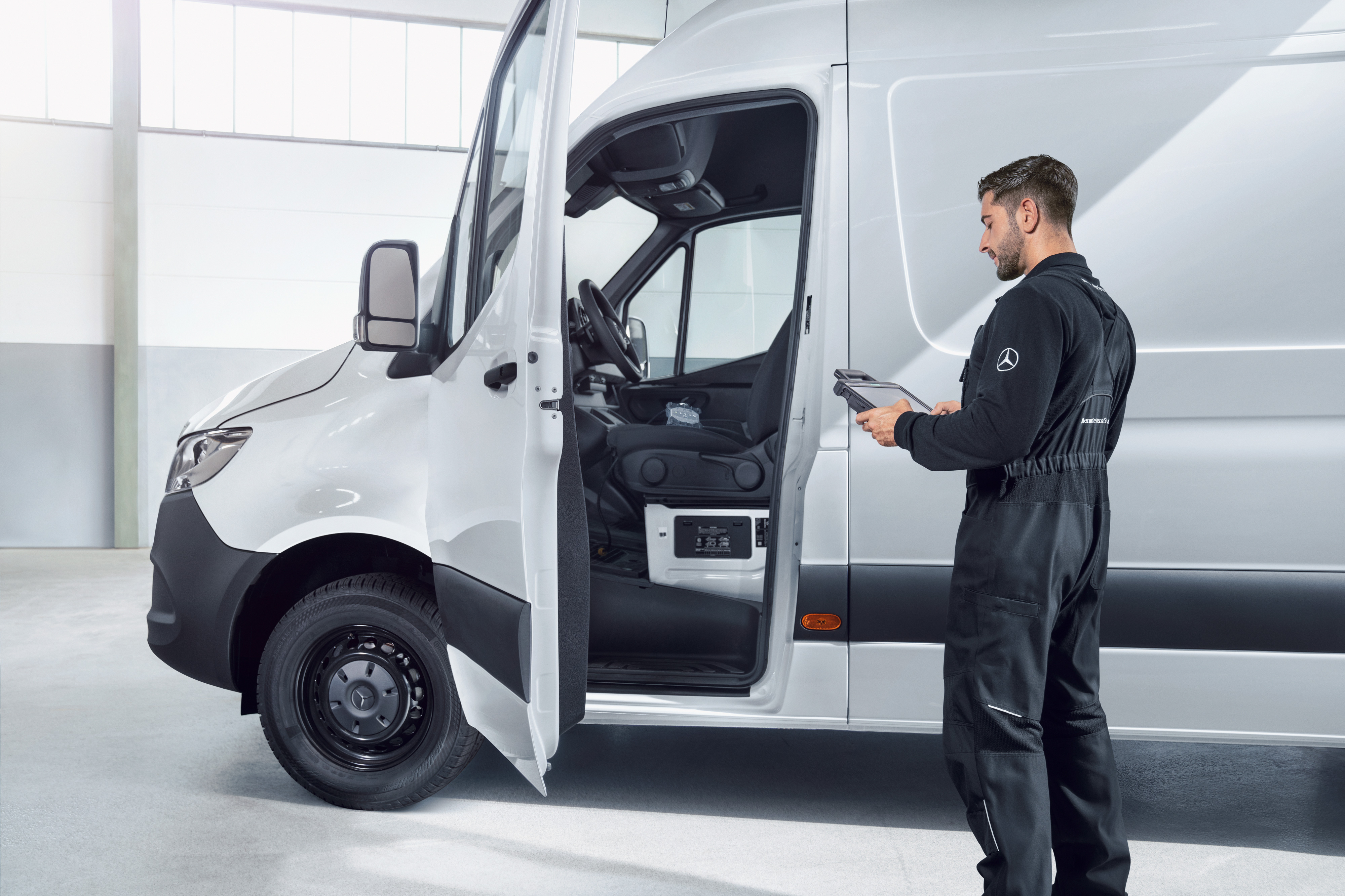 Mercedes-Benz | Serviços de frota de veículos comerciais ligeiras | Manutenção de veículos Um técnico verifica um veículo comercial ligeiro Mercedes-Benz Sprinter branco com um tablet.