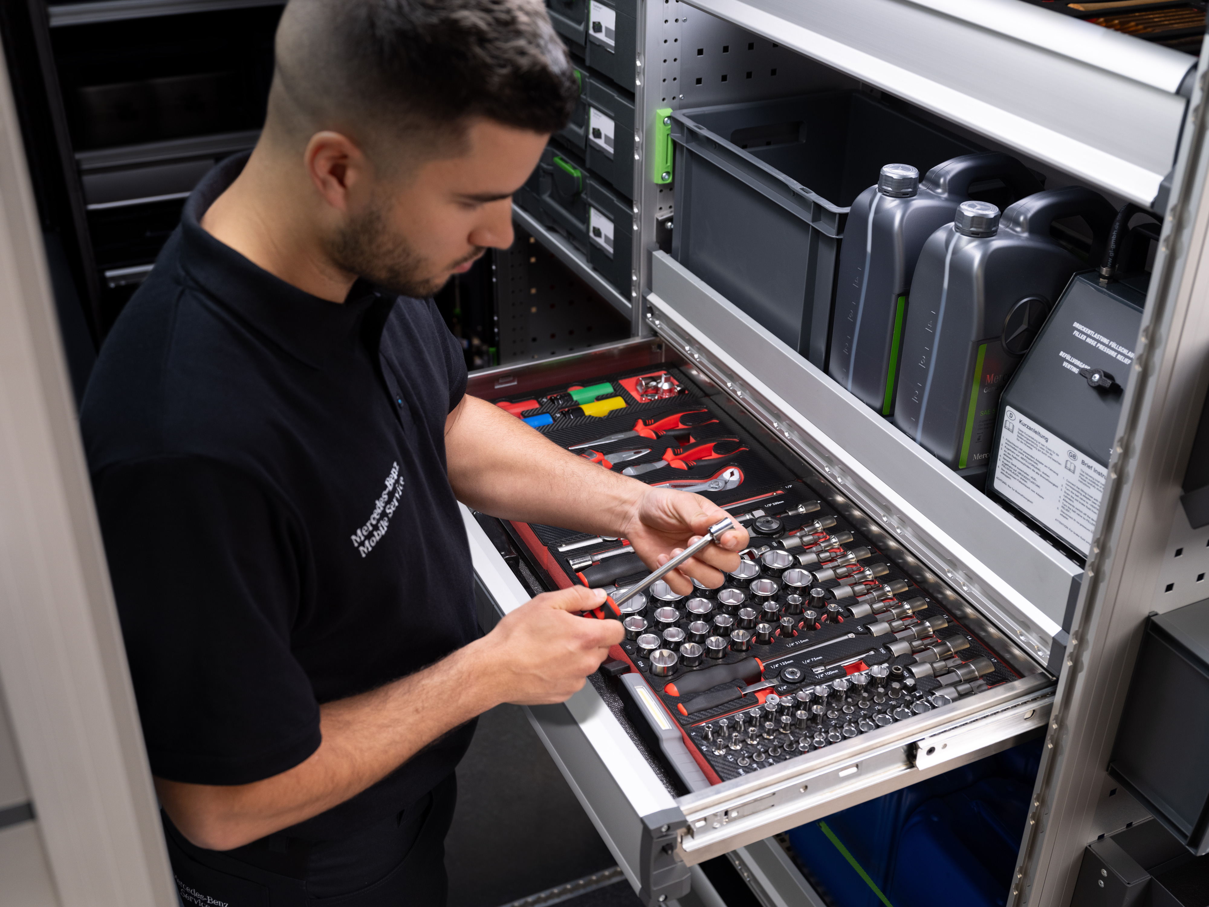 Mercedes-Benz | Serviço móvel | Eletrónica Um técnico seleciona um item de uma gaveta cheia de ferramentas.